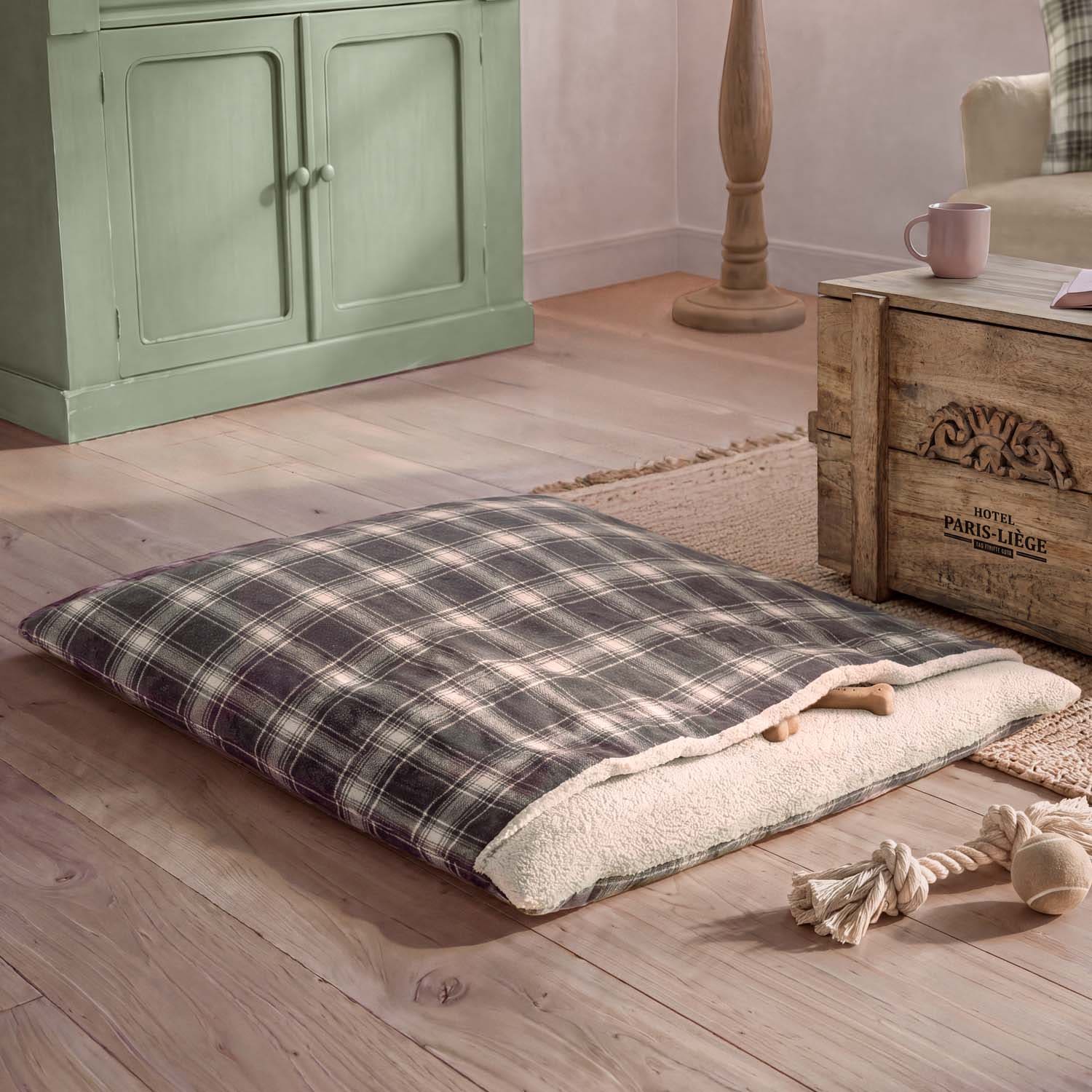 Cuscino a quadri con interno morbido color crema su pavimento in legno in ambiente accogliente