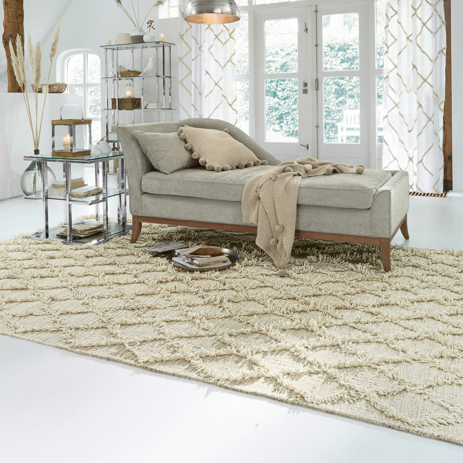 Tappeto Yoann Chaise longue grigia in tessuto con gambe in legno su tappeto beige in soggiorno luminoso