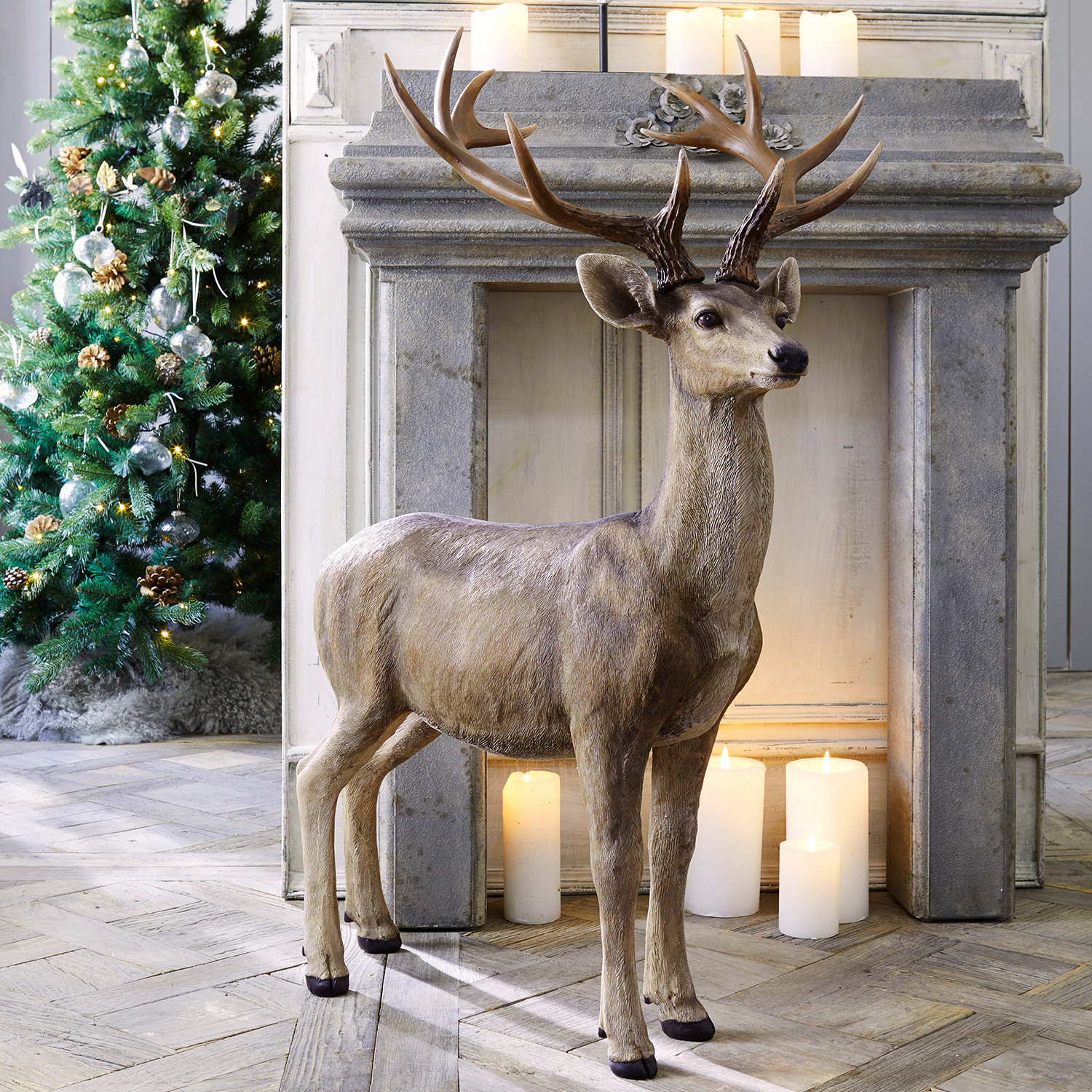 Cervo Storm Figura decorativa di cervo in resina marrone naturale davanti a camino con candele accese