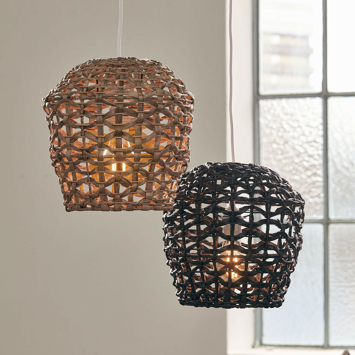 Coppia di paralumi Orsenda Due lampade a sospensione in rattan intrecciato naturale e nero, illuminazione decorativa per interni