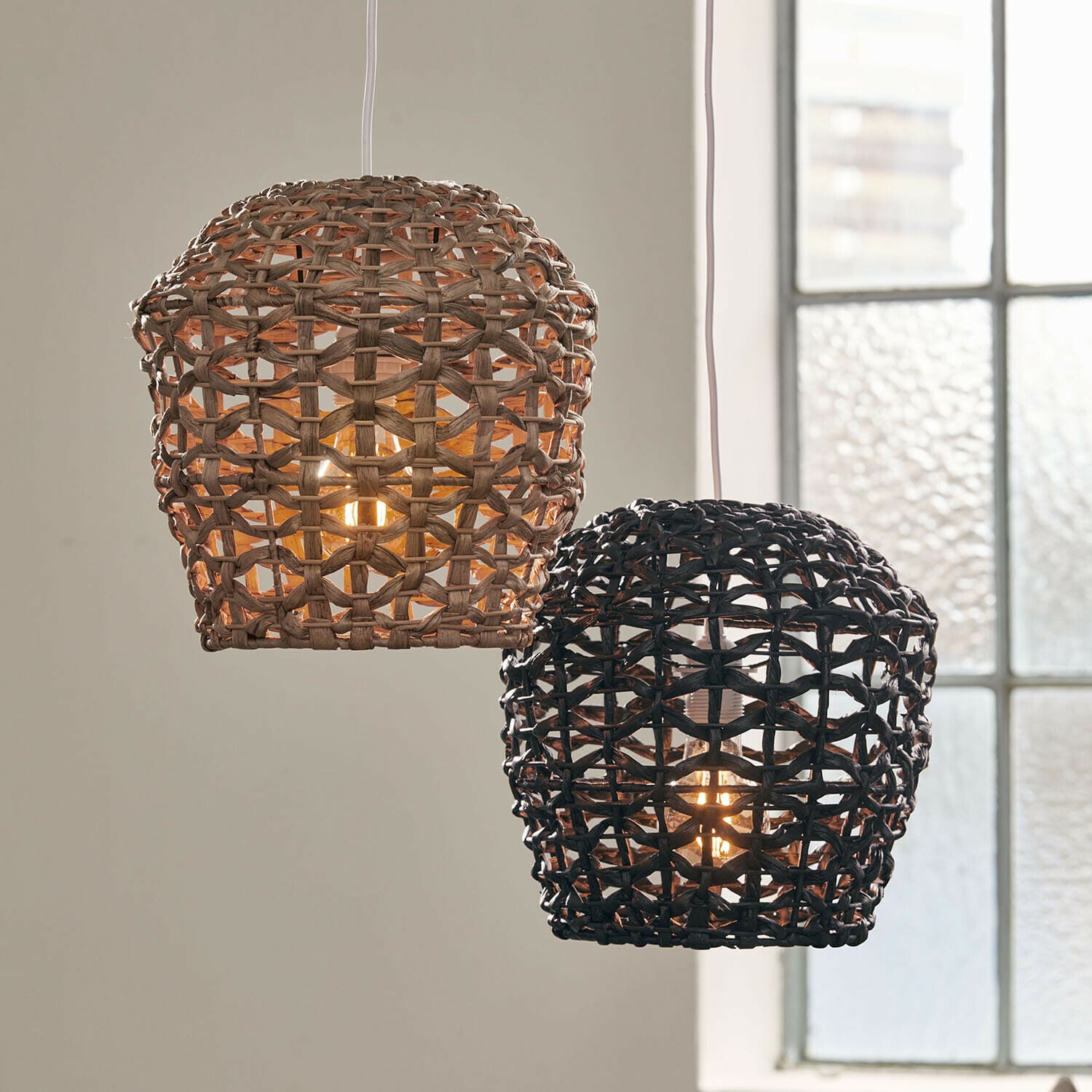 Coppia di paralumi Orsenda Due lampade a sospensione in rattan intrecciato naturale e nero, illuminazione decorativa per interni
