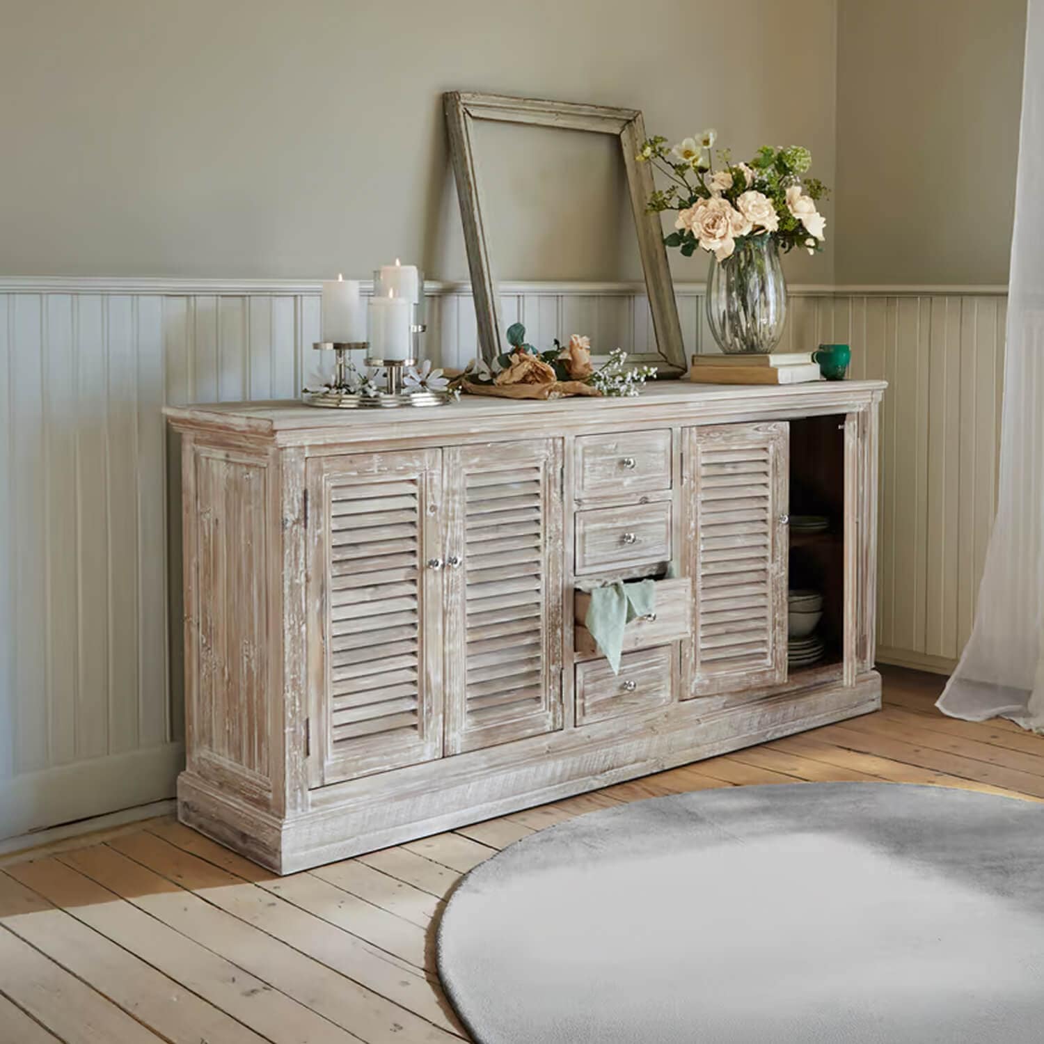 Credenza rustica in legno bianco effetto invecchiato con decorazioni e candele in soggiorno