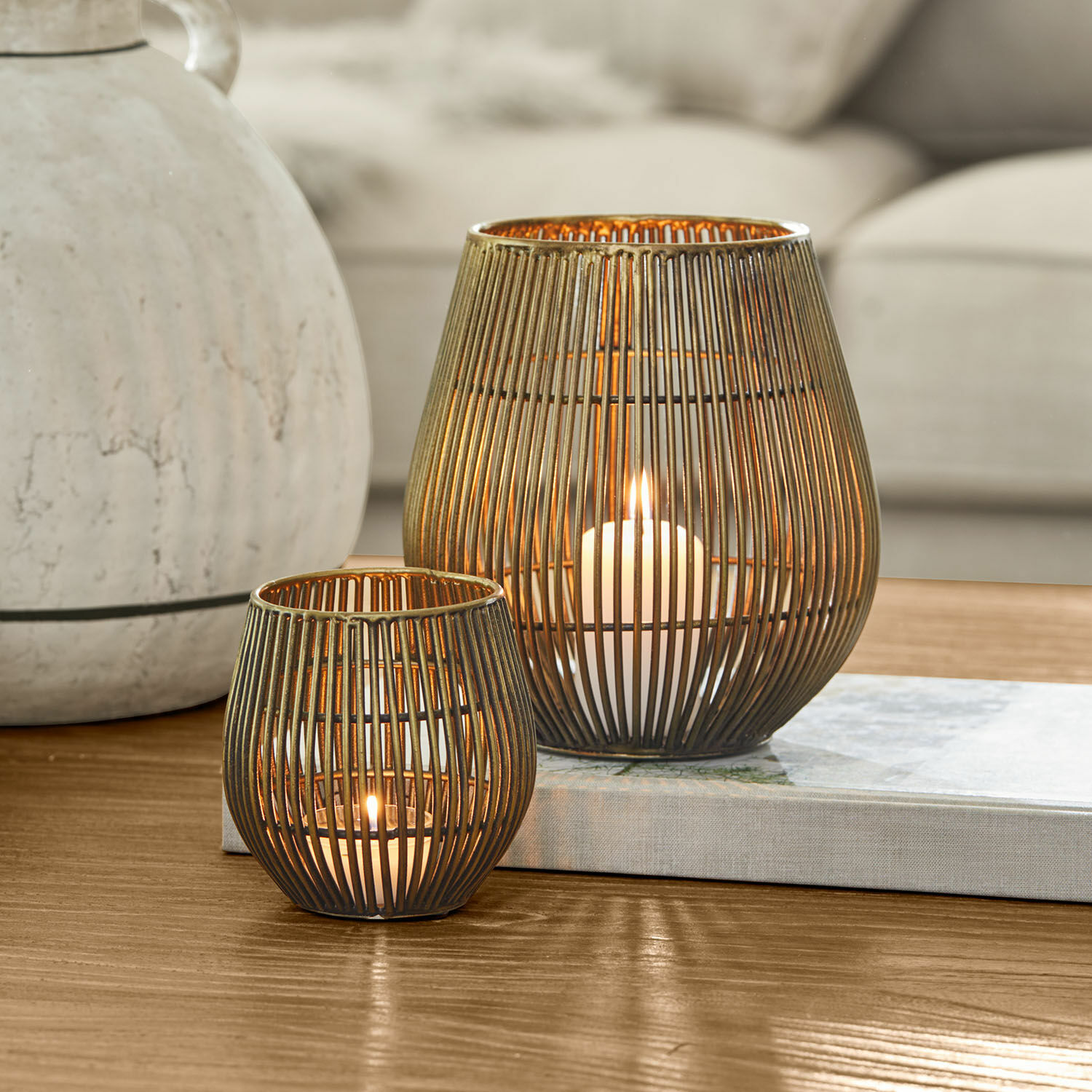 Coppia di lanterne Pontarino Due lanterne in metallo color ottone con stecche verticali e candele accese all'interno, decorazione da tavolo
