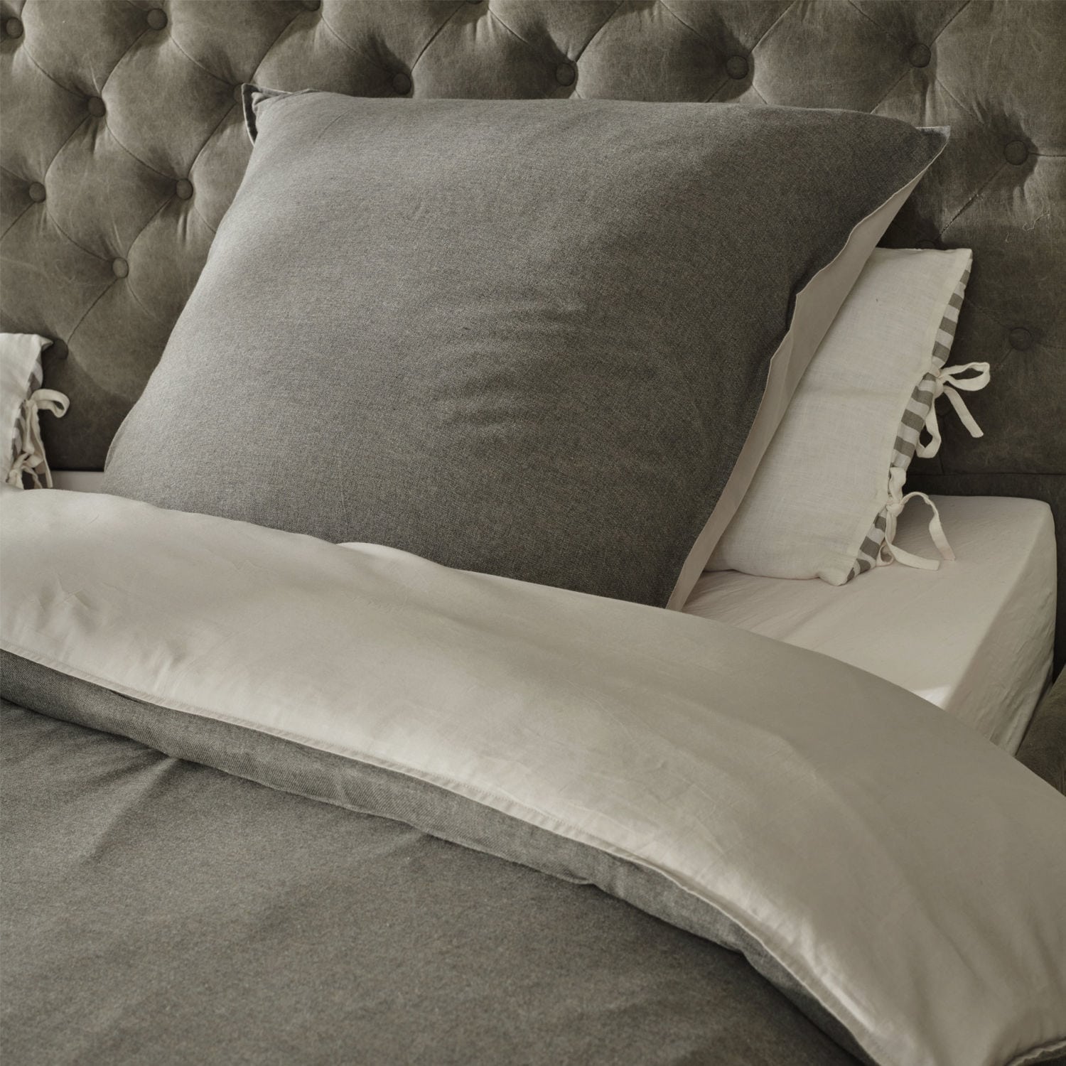 Biancheria da letto Mynatt Biancheria da letto grigia in tessuto morbido su letto con testiera capitonné, confortevole e elegante