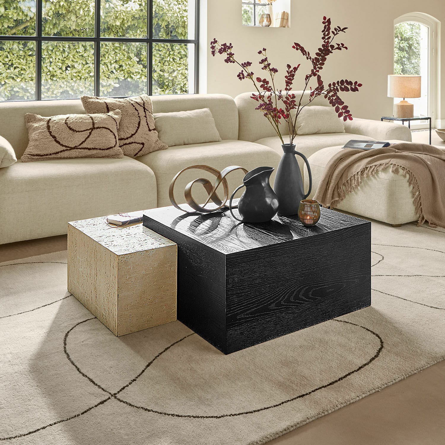 Tavolino da salotto Caleneuve Soggiorno moderno con divano beige e due tavolini in legno e pietra, decorazioni sul tavolo