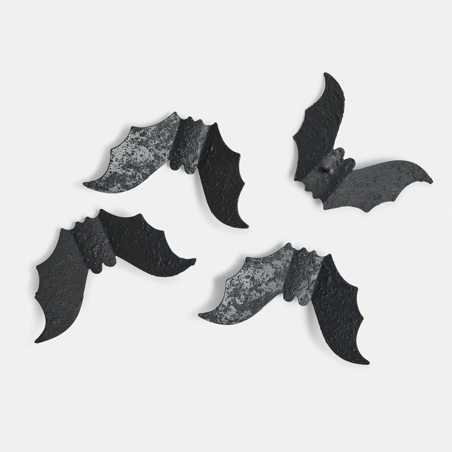 Set di 4 spille decorative Brynnach Quattro decorazioni in metallo nero a forma di pipistrello con superficie ruvida su sfondo bianco
