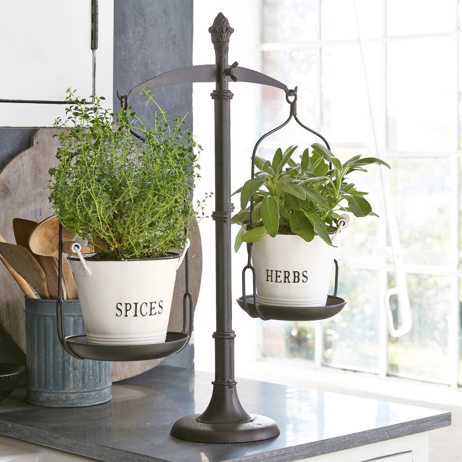 Bilancia decorativa Tynne Bilancia in metallo nero con due vasi bianchi per erbe e spezie in cucina luminosa