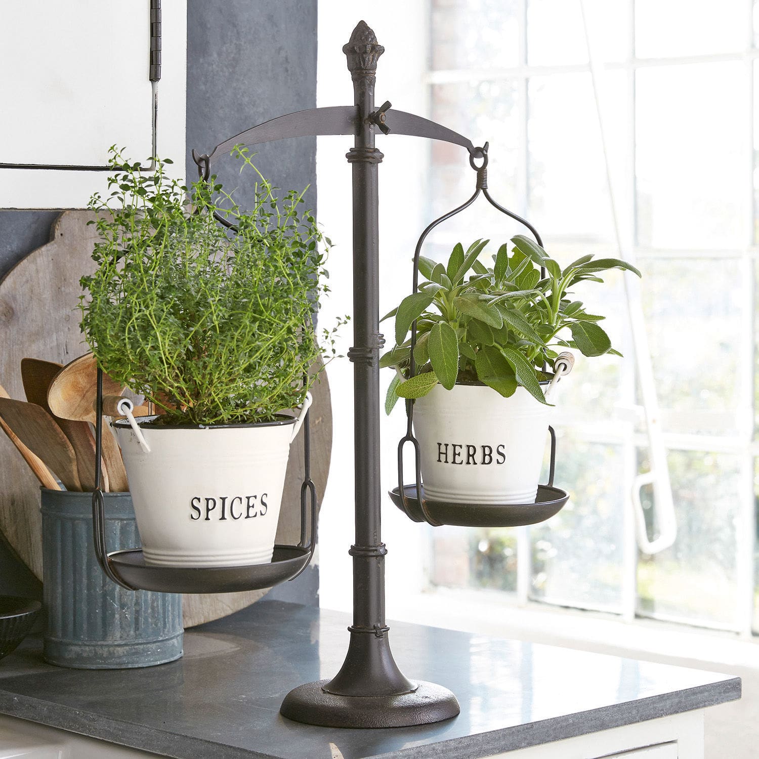 Bilancia decorativa Tynne Bilancia in metallo nero con due vasi bianchi per erbe e spezie in cucina luminosa