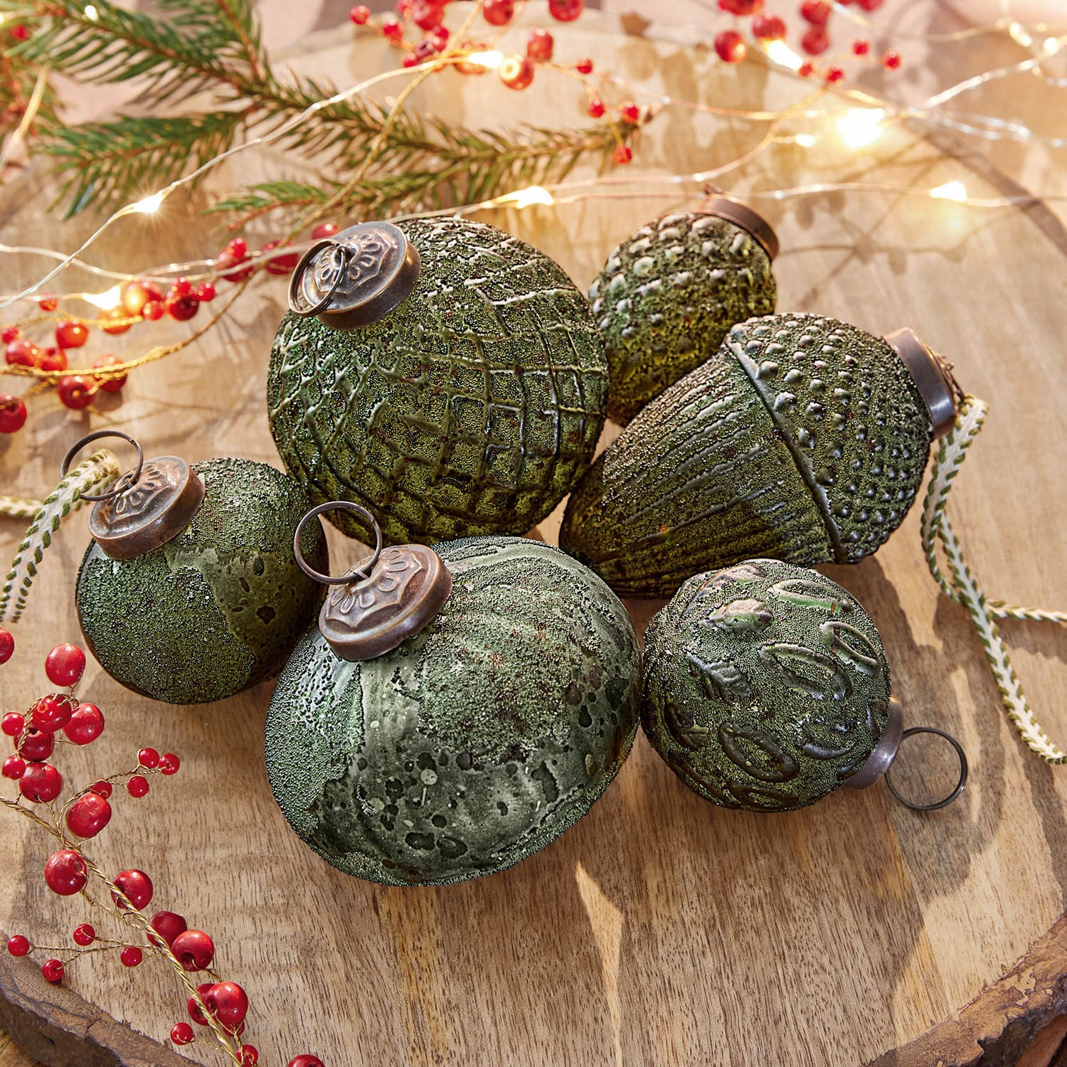 Set di 6 decorazioni natalizie Lento Set di decorazioni natalizie verdi con texture e ganci metallici su sfondo in legno