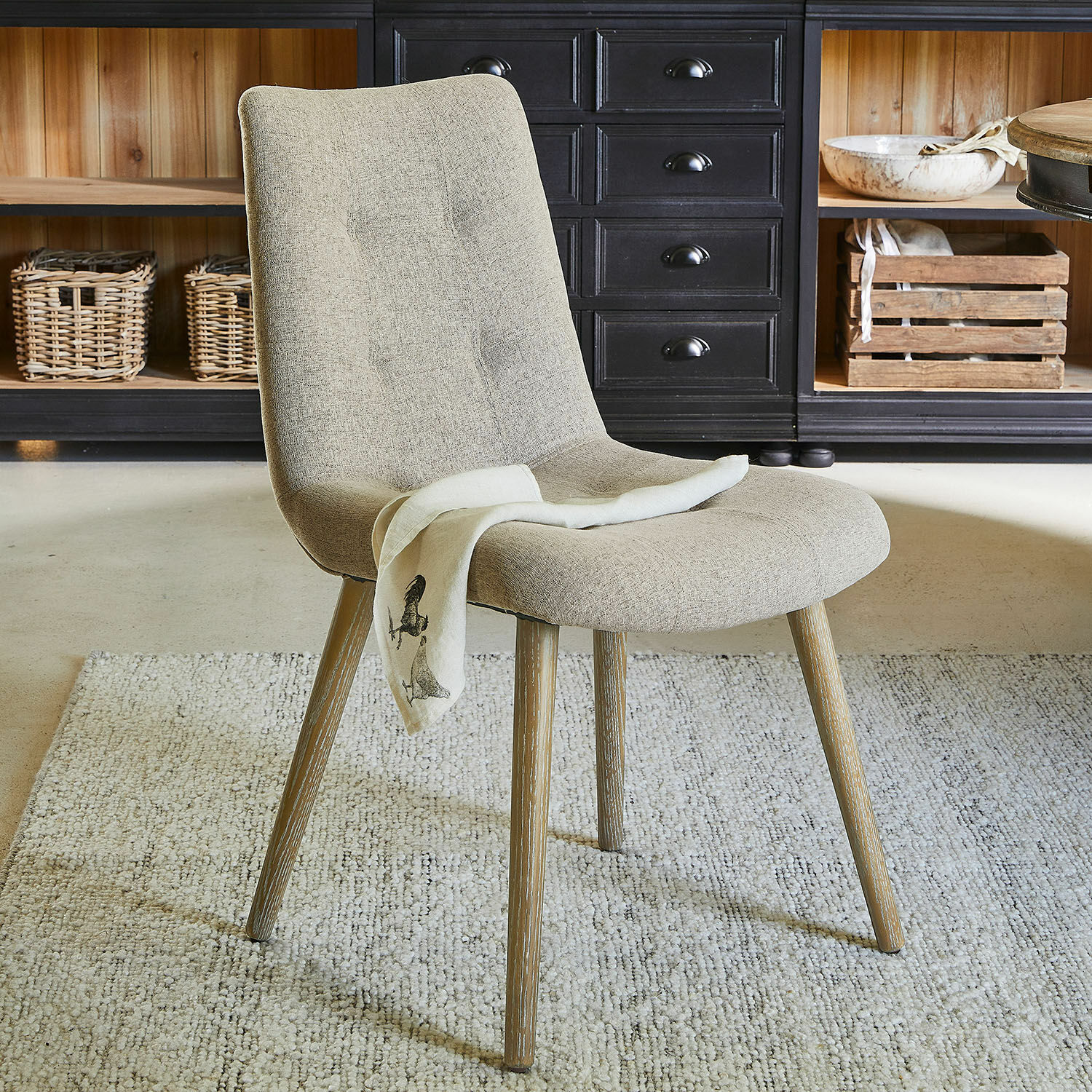 Sedia Vietri Sedia imbottita beige con gambe in legno su tappeto in ambiente moderno