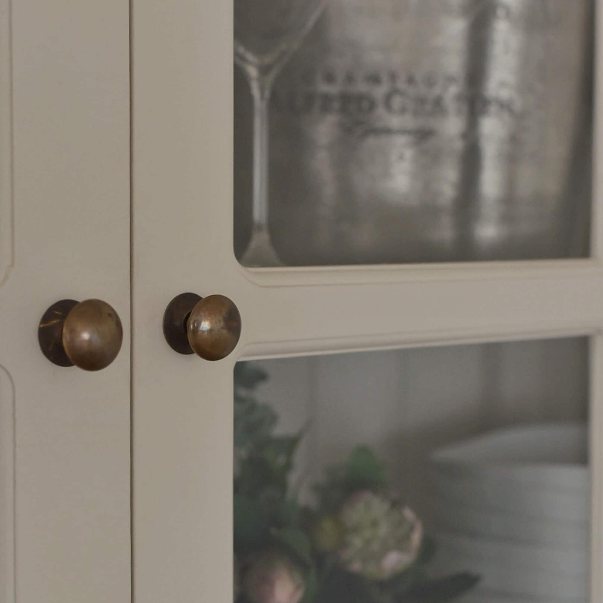 Dettaglio di armadio in legno bianco con pomelli in ottone, stile rustico, mobile contenitore