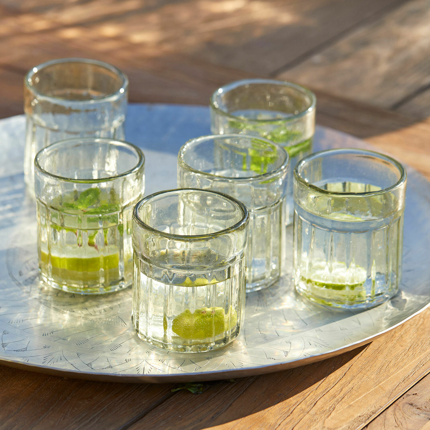 Set di 6 bicchieri Roseville Sei bicchieri in vetro trasparente con lime su un vassoio metallico su tavolo di legno