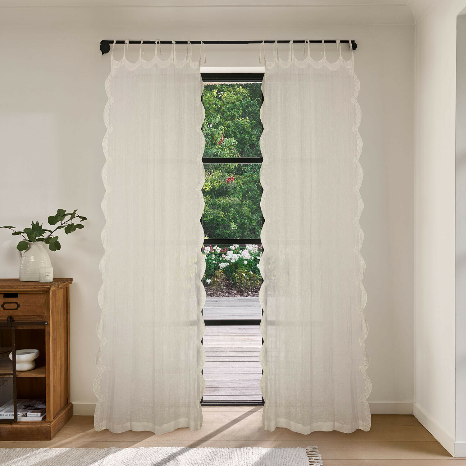 Tendina Dolcin Tende bianche trasparenti con bordo ondulato in ambiente luminoso con vista sul giardino