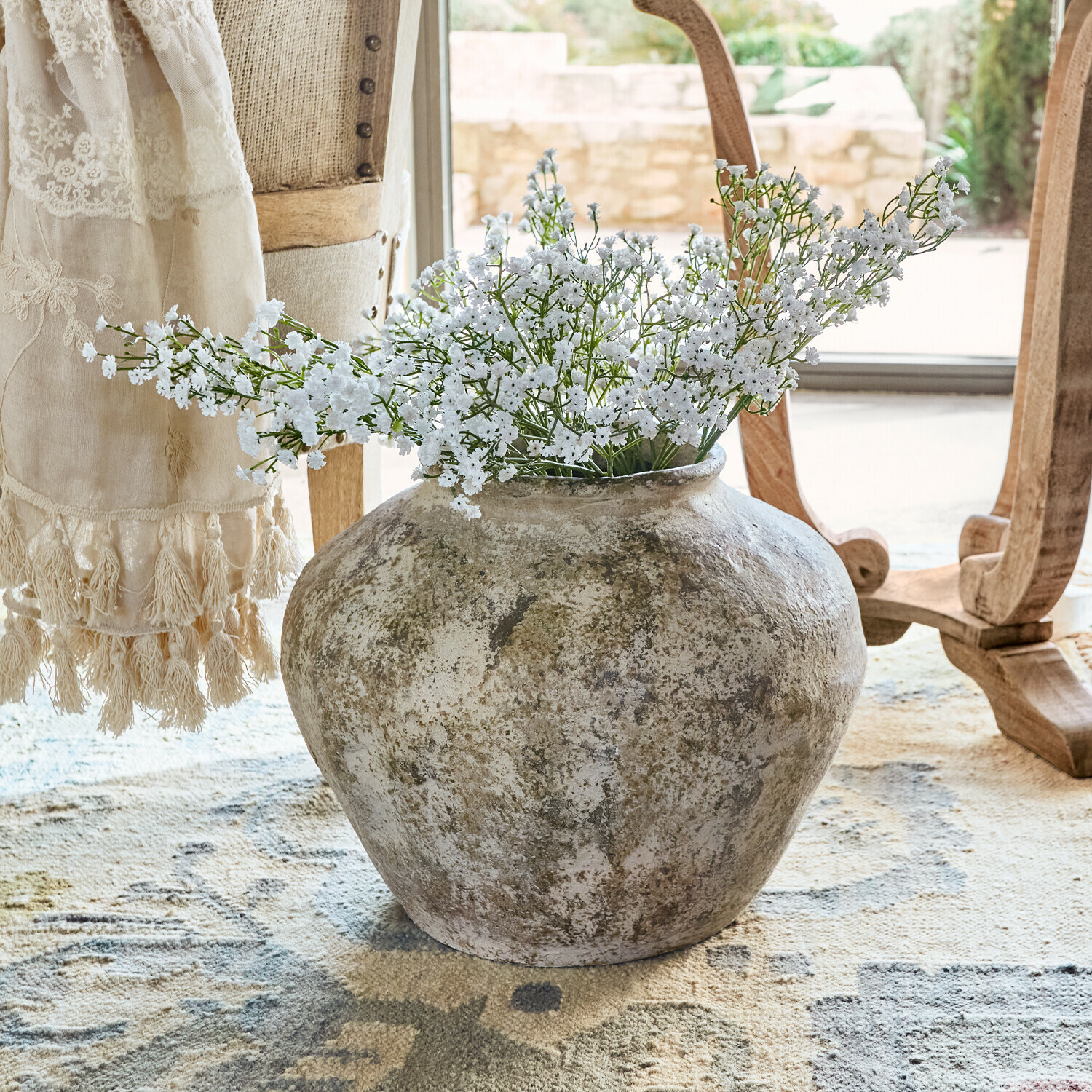 Vaso Champs Grande vaso in ceramica rustica con fiori bianchi su tappeto in ambiente luminoso