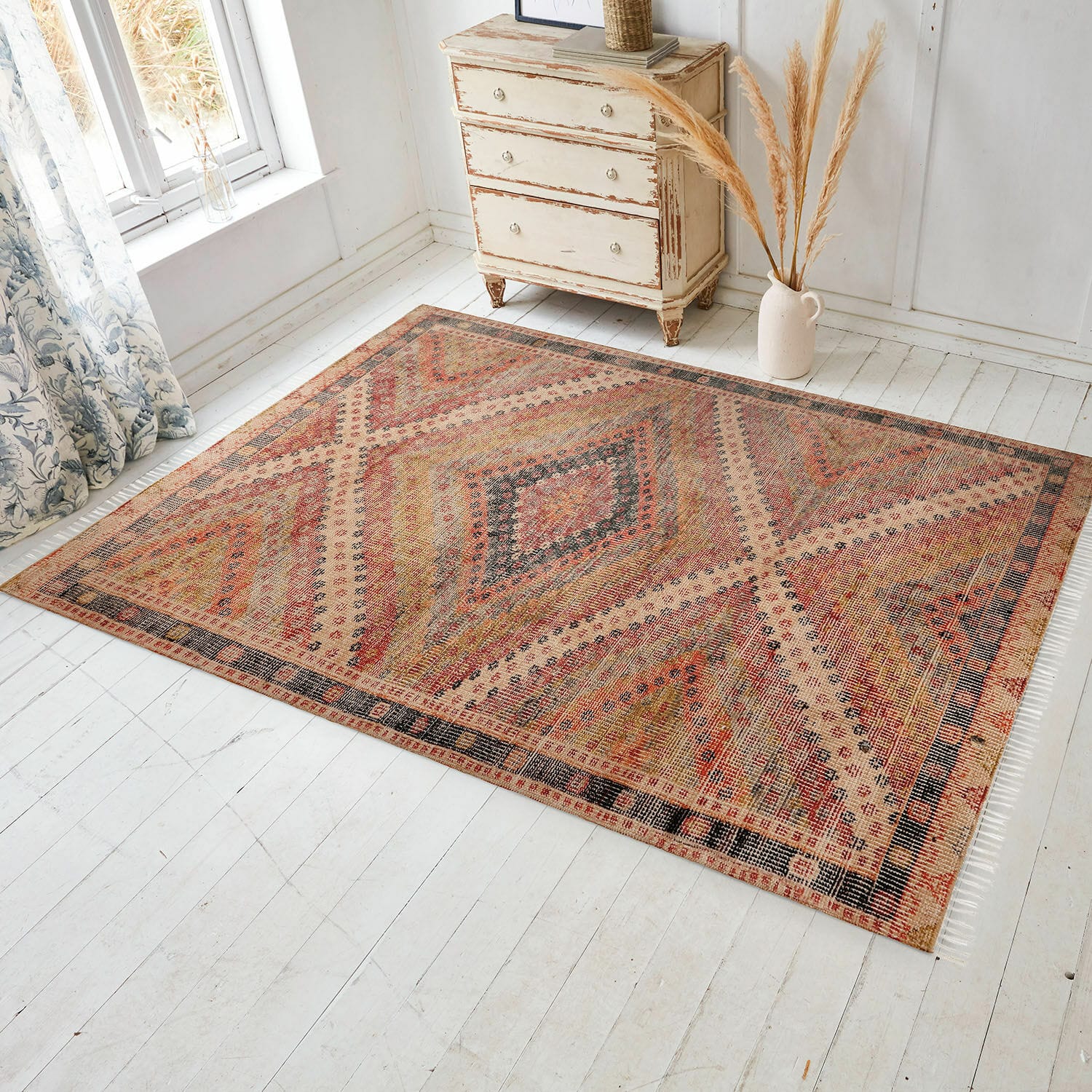 Tappeto per esterni e interni Mildura Tappeto con motivo geometrico in tonalità calde di rosso e beige su pavimento in legno chiaro