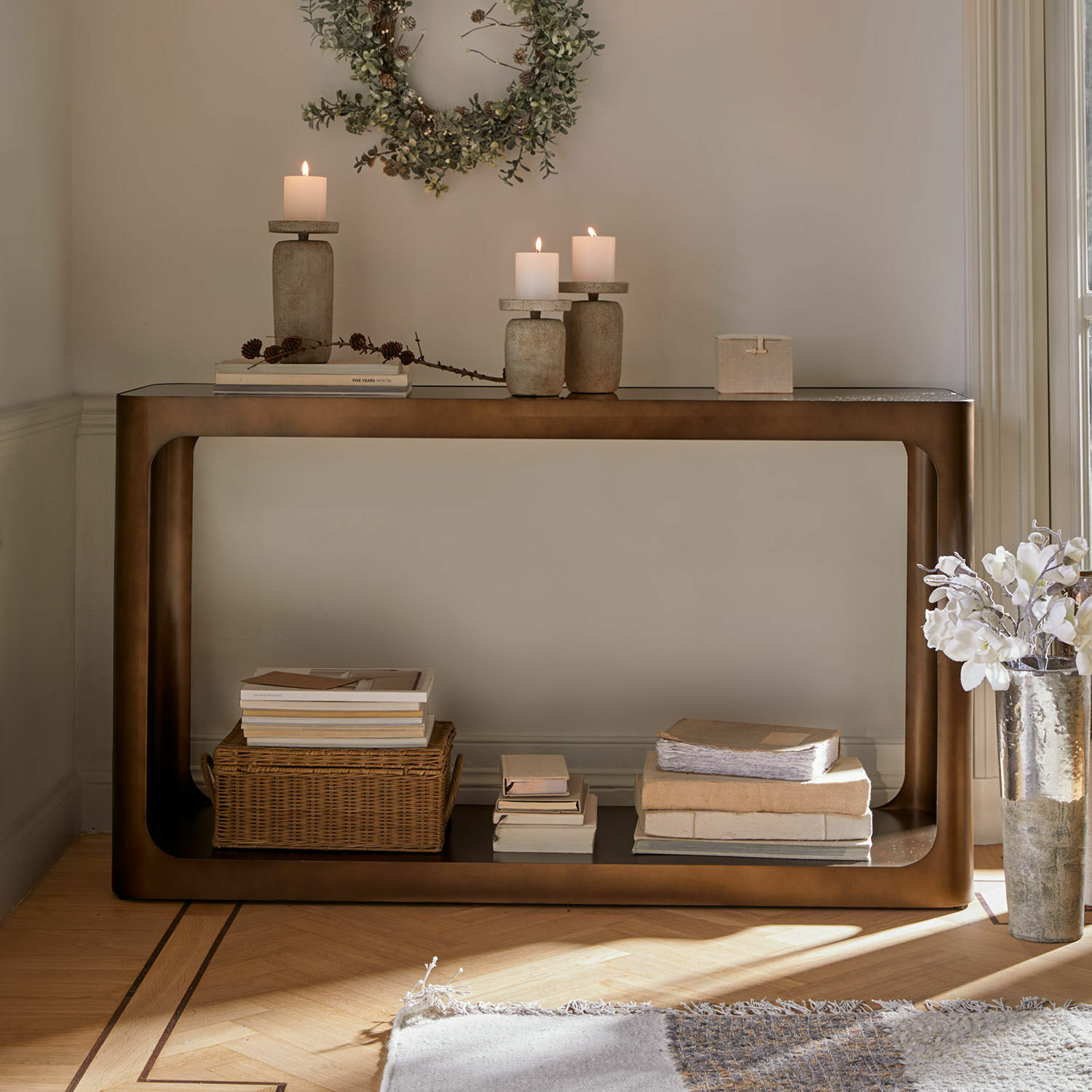 Consolle in metallo marrone con ripiano, decorata con candele e libri, mobile moderno per soggiorno