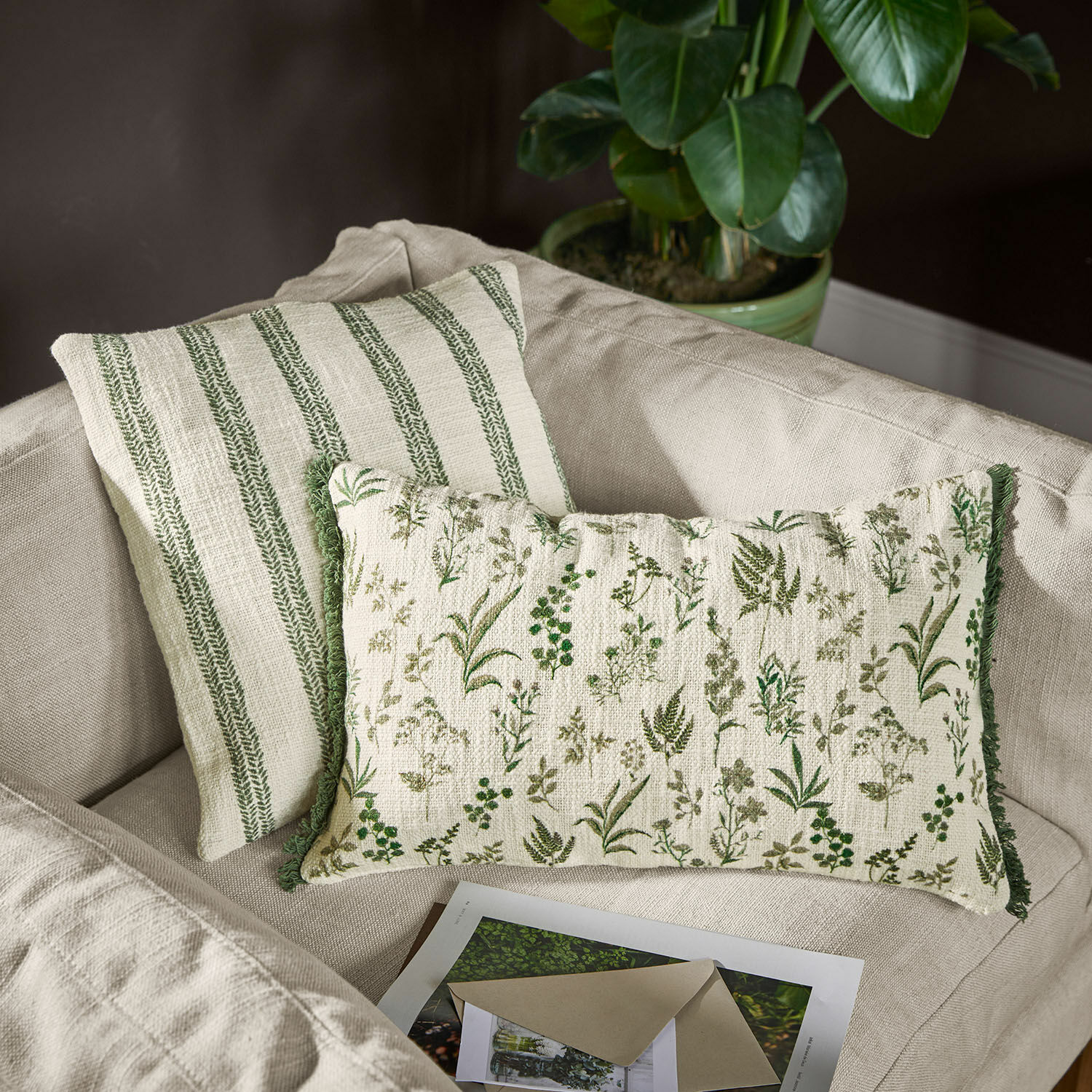 Coppia di copricuscini Wescombe Cuscini decorativi reversibili in cotone con motivi vegetali verdi e righe su divano beige