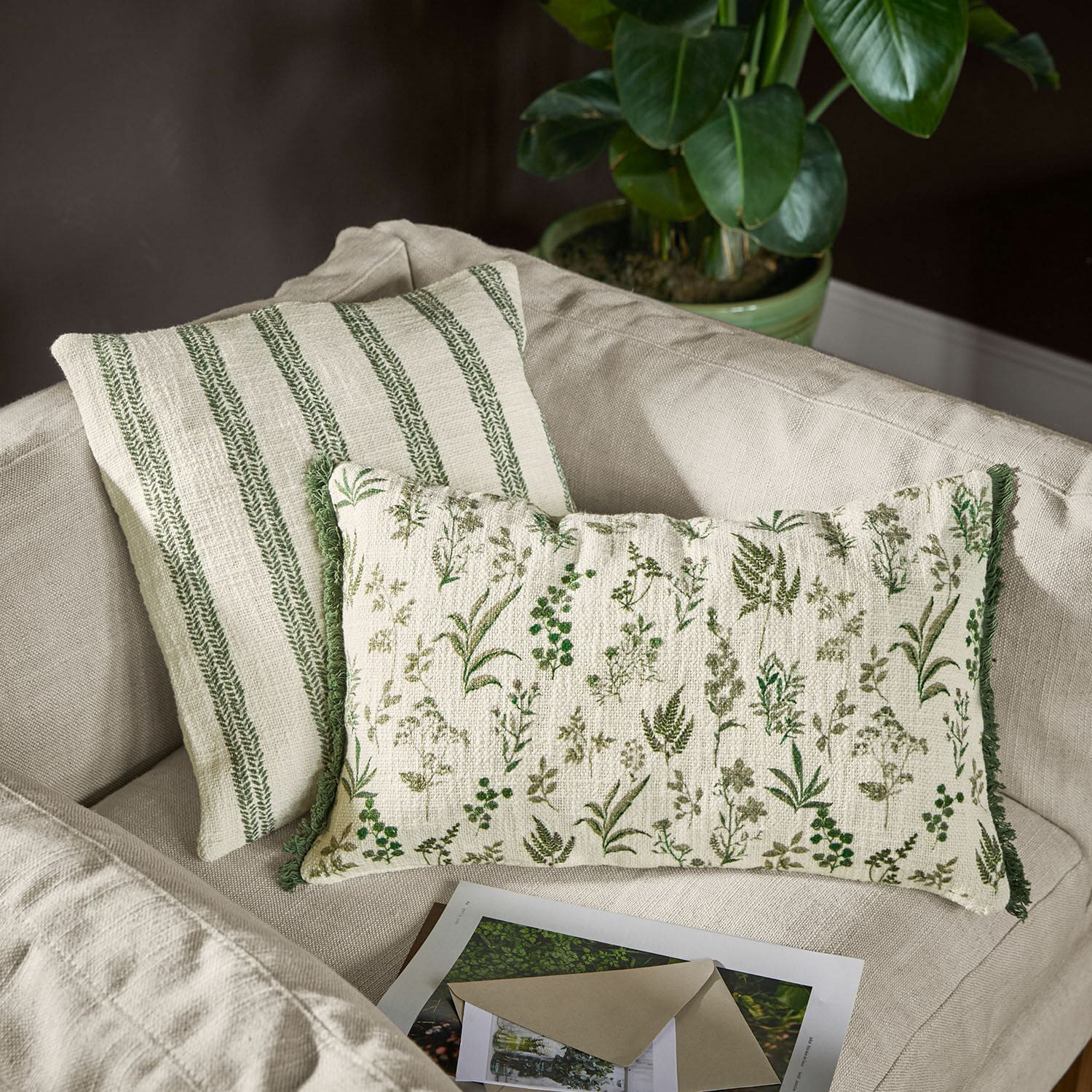 Coppia di copricuscini Wescombe Cuscini decorativi reversibili in cotone con motivi vegetali verdi e righe su divano beige