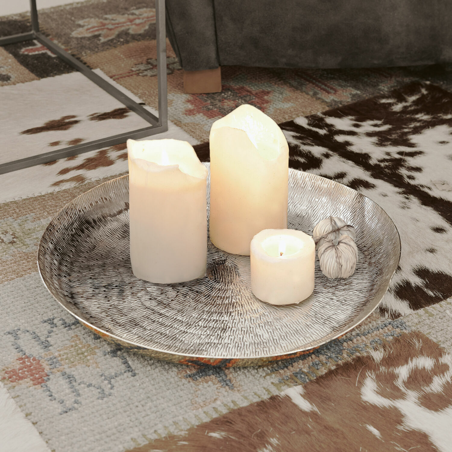 Vassoio Caelan Vassoio decorativo argentato con tre candele bianche su tappeto con motivo animale