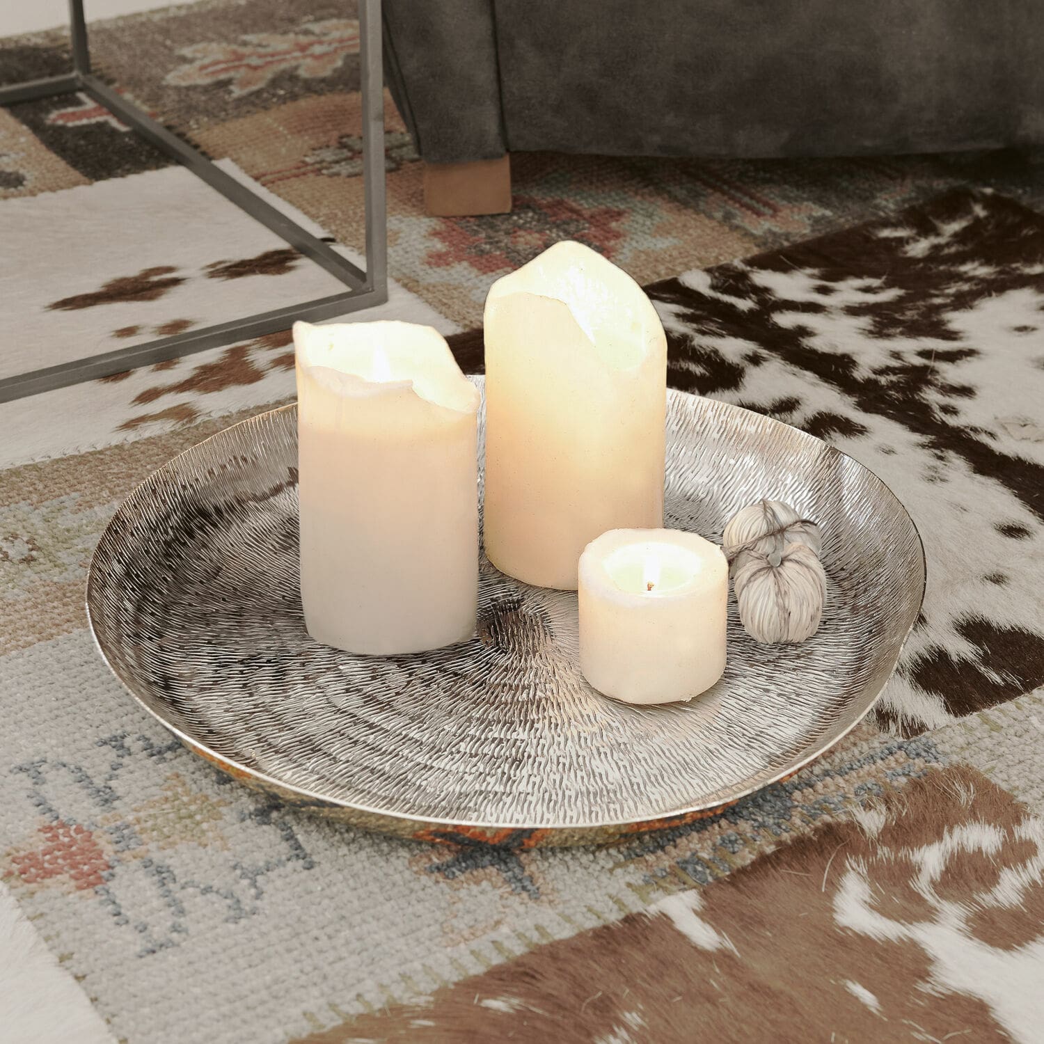 Vassoio Caelan Vassoio decorativo argentato con tre candele bianche su tappeto con motivo animale