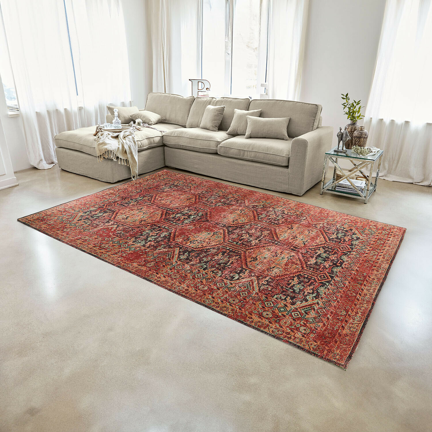 Tappeto Incantaro Tappeto rosso con motivo orientale su pavimento chiaro in soggiorno moderno con divano beige