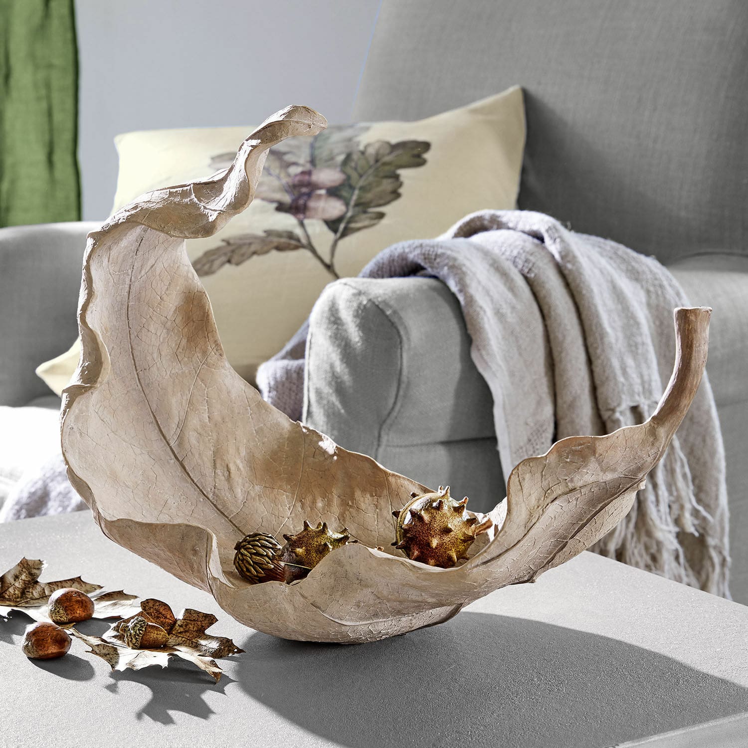 Centrotavola Vibius Ciotola decorativa a forma di foglia in materiale naturale beige su tavolo in soggiorno