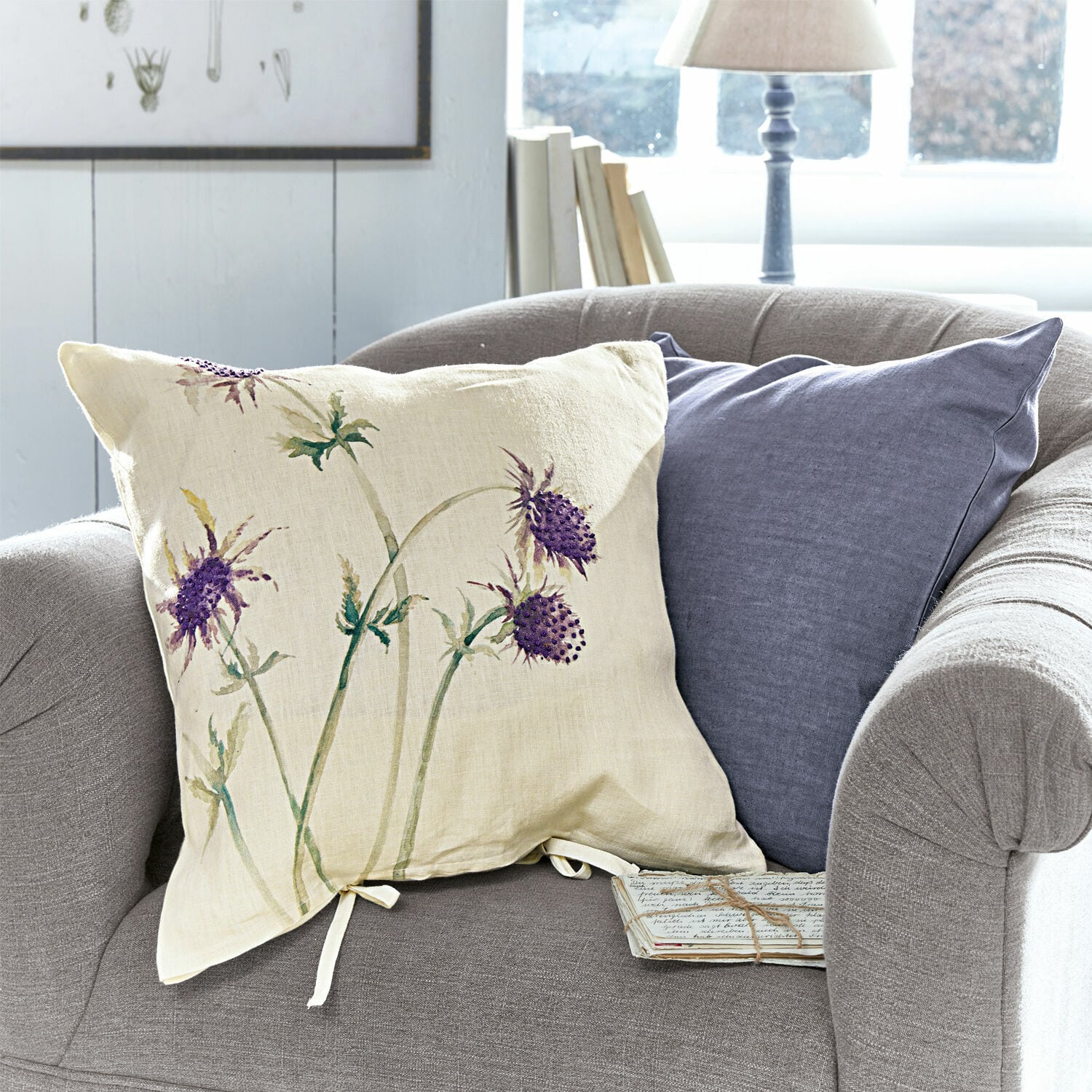 Coppia di copricuscini Épine Cuscino beige in lino con motivo floreale viola su divano grigio, decorazione d'interni