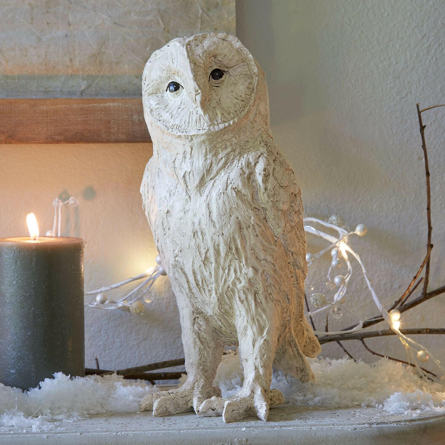 Civetta decorativa Heriette Figura decorativa di gufo in materiale chiaro su tavolo festivo con candela e luci decorative