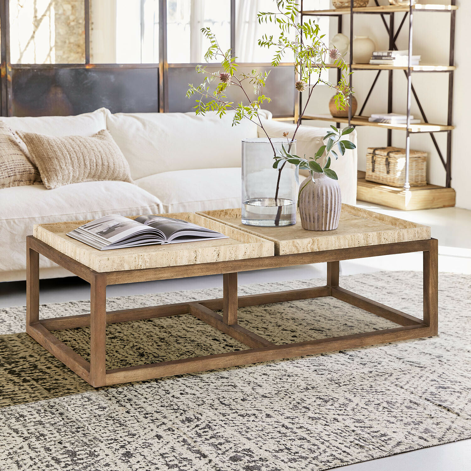 Tavolino da salotto Edwyn Tavolino da salotto in legno chiaro con piano in pietra beige in un soggiorno luminoso e moderno