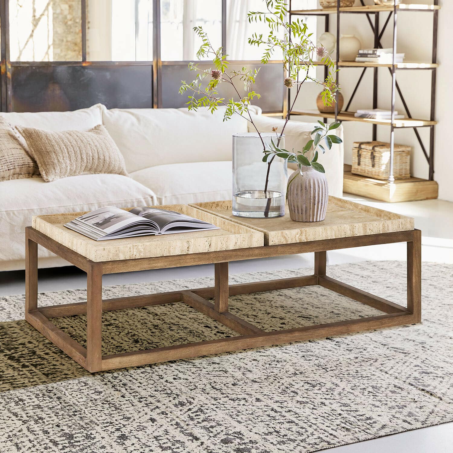 Tavolino da salotto Edwyn Tavolino da salotto in legno chiaro con piano in pietra beige in un soggiorno luminoso e moderno