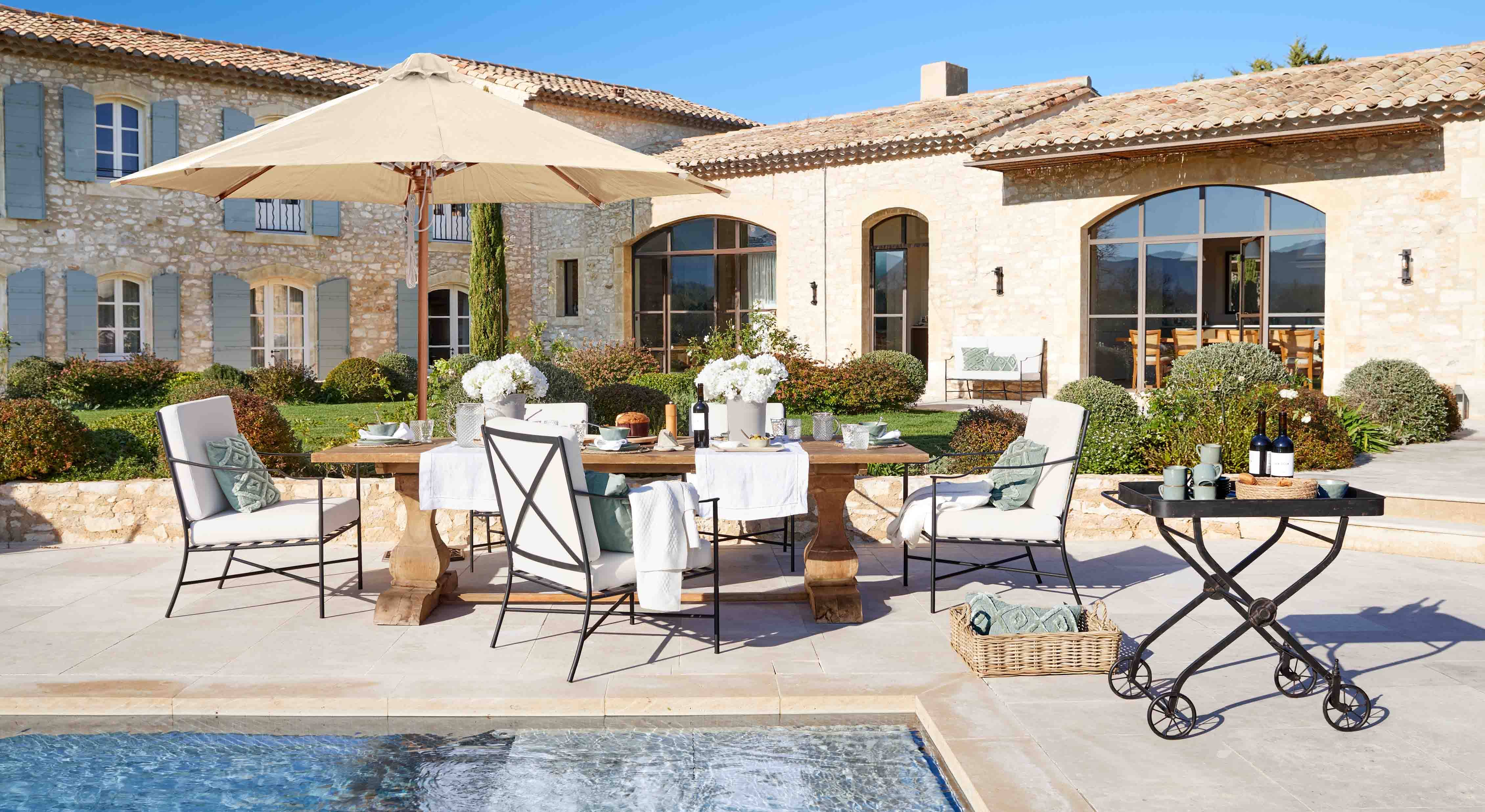 Set di mobili da giardino elegante con ombrellone beige e tavolo in legno vicino alla piscina