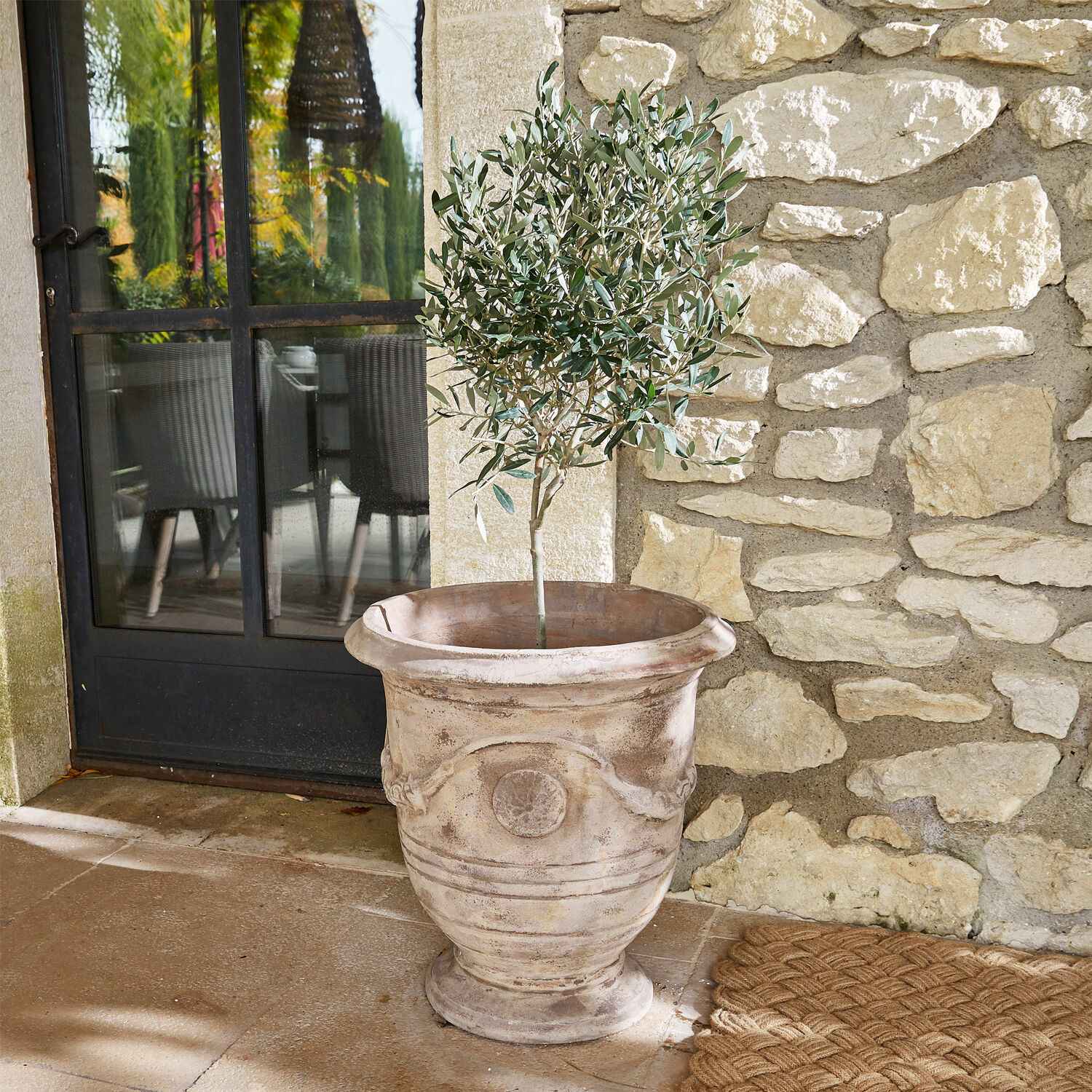 Portavaso Garwood Grande vaso decorativo in terracotta beige con pianta verde su terrazza in pietra