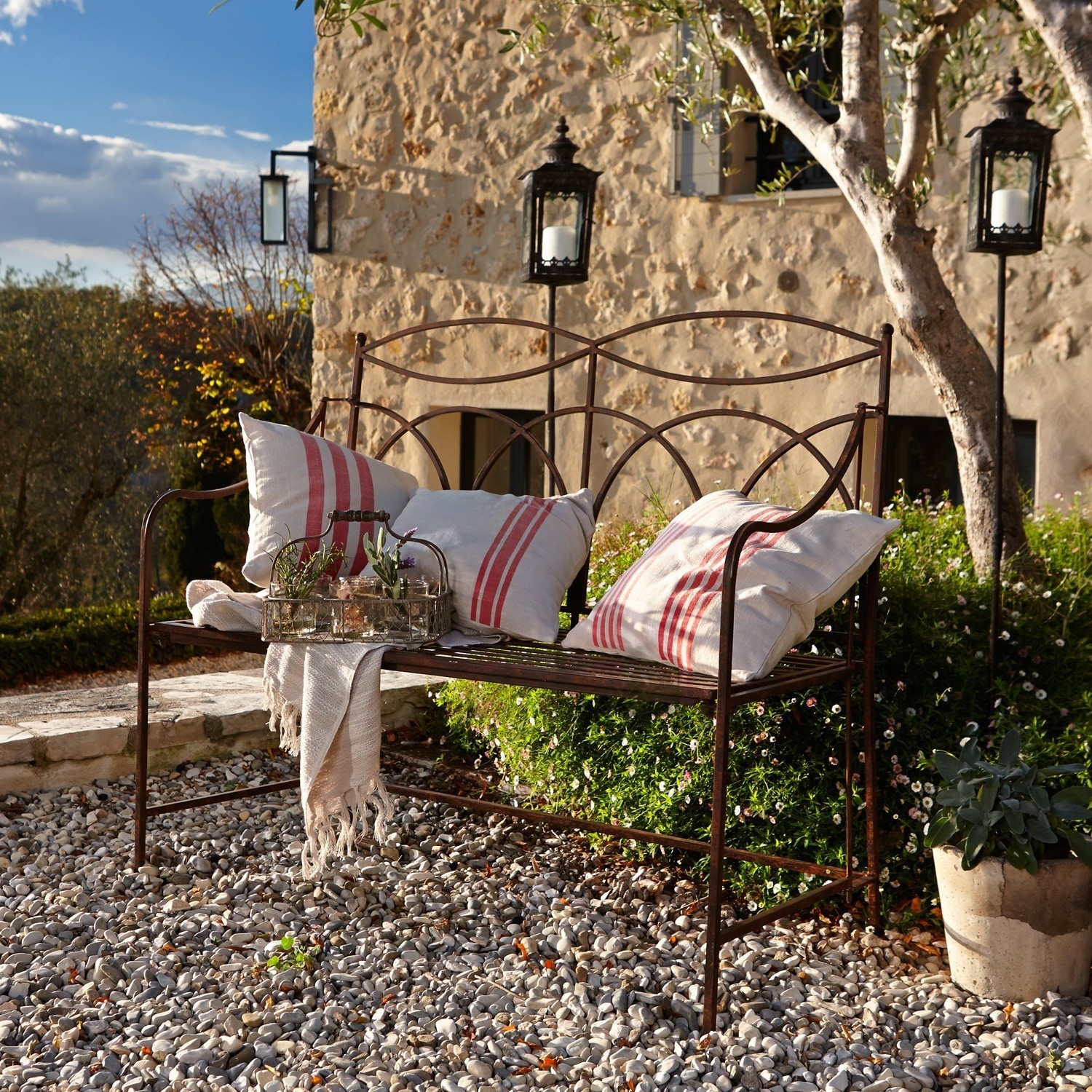 Panchina Jablines Panchina da giardino in metallo con cuscini bianchi a righe rosse su ghiaia