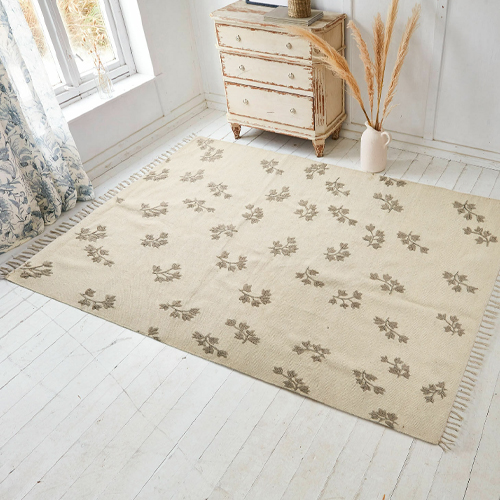 Tappeto beige con motivo floreale e frange, materiale morbido, decorazione per pavimento in stanza luminosa
