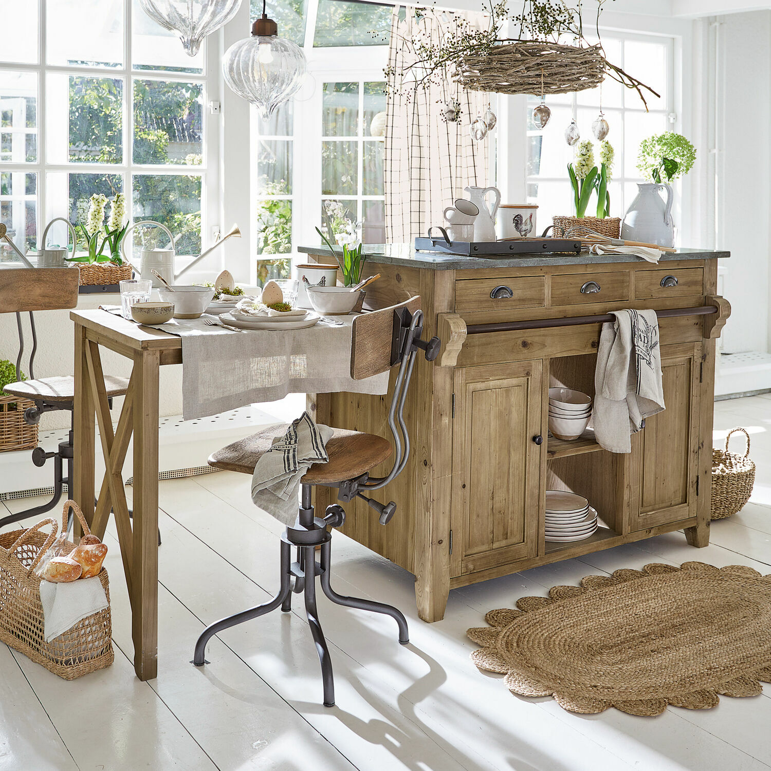 Mobile da cucina Évain Cucina rustica con isola e tavolo in legno, materiali naturali e decorazioni chiare in ambiente luminoso