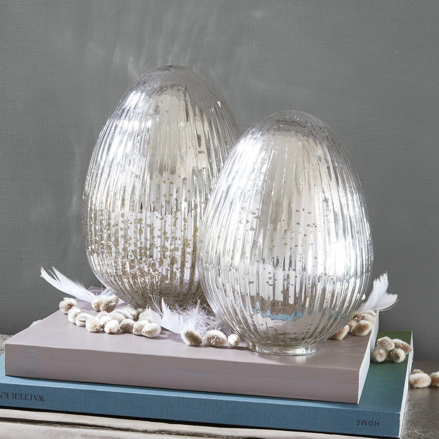 Coppia di uova di Pasqua Duvera Due portacandele decorativi in vetro argentato su libri, decorati con piume e amenti