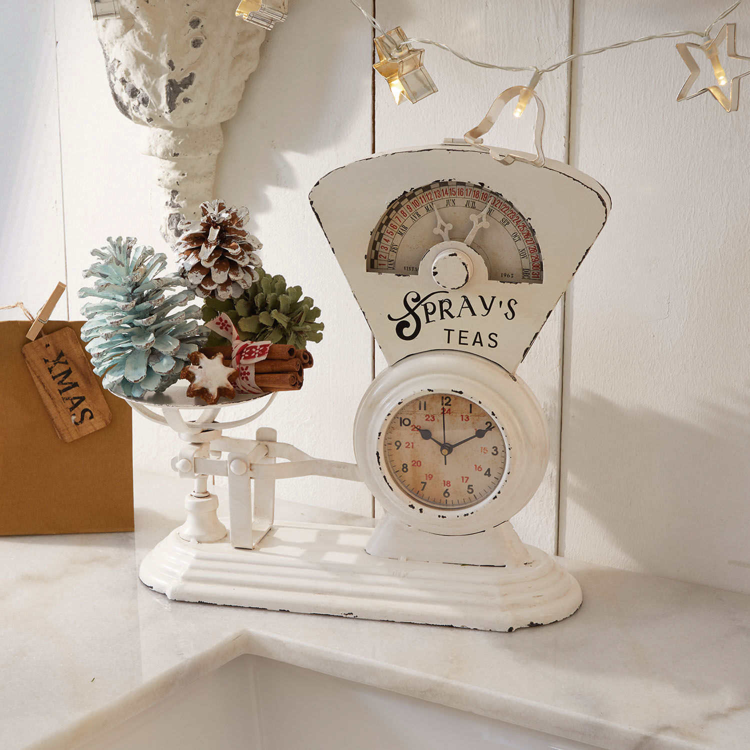 Bilancia da cucina bianca in metallo con decorazioni natalizie e pigne sul piano di lavoro