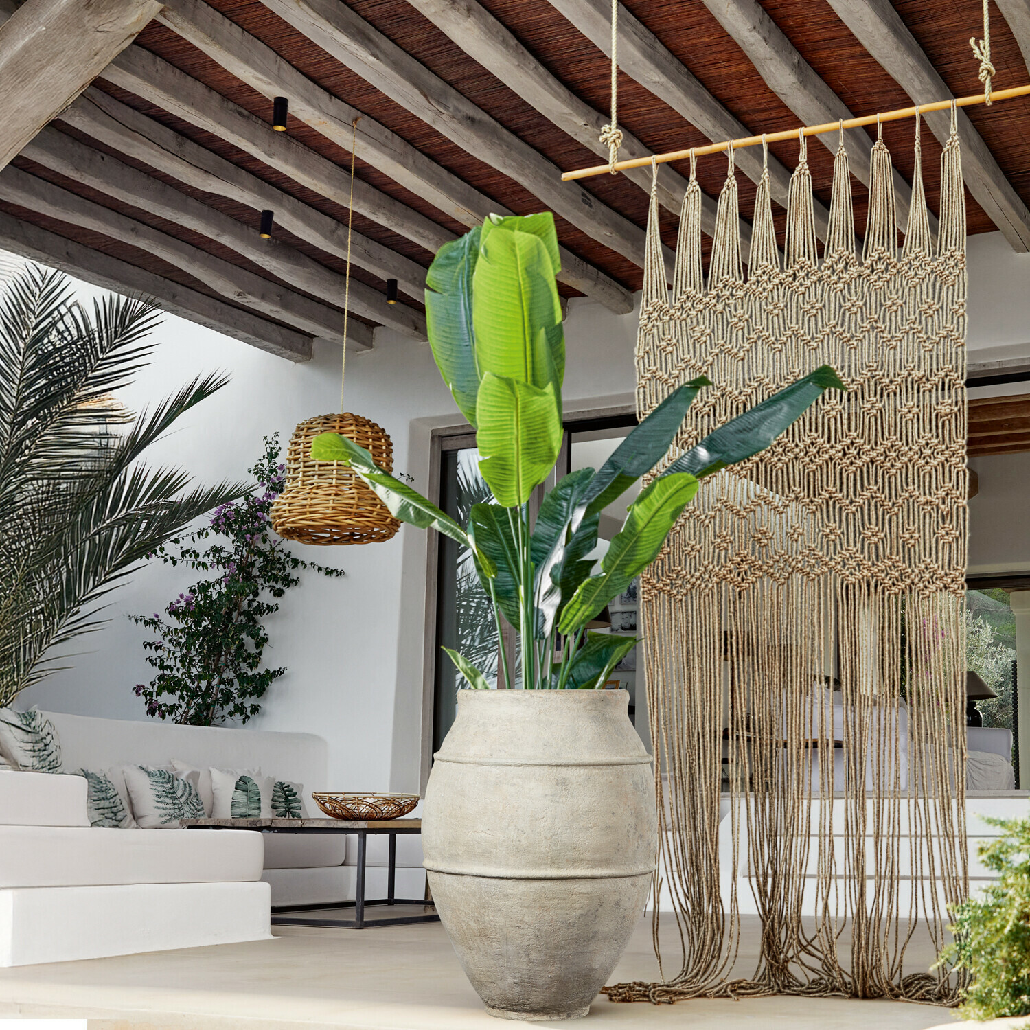 Pianta decorativa Lennidas Grande vaso in pietra chiara con pianta verde in soggiorno moderno con macramè e lampada in vimini
