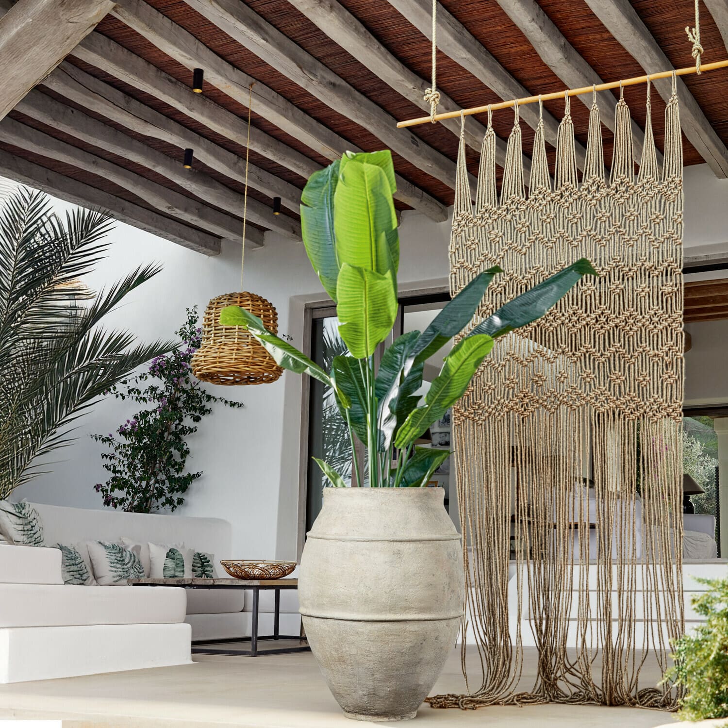Pianta decorativa Lennidas Grande vaso in pietra chiara con pianta verde in soggiorno moderno con macramè e lampada in vimini