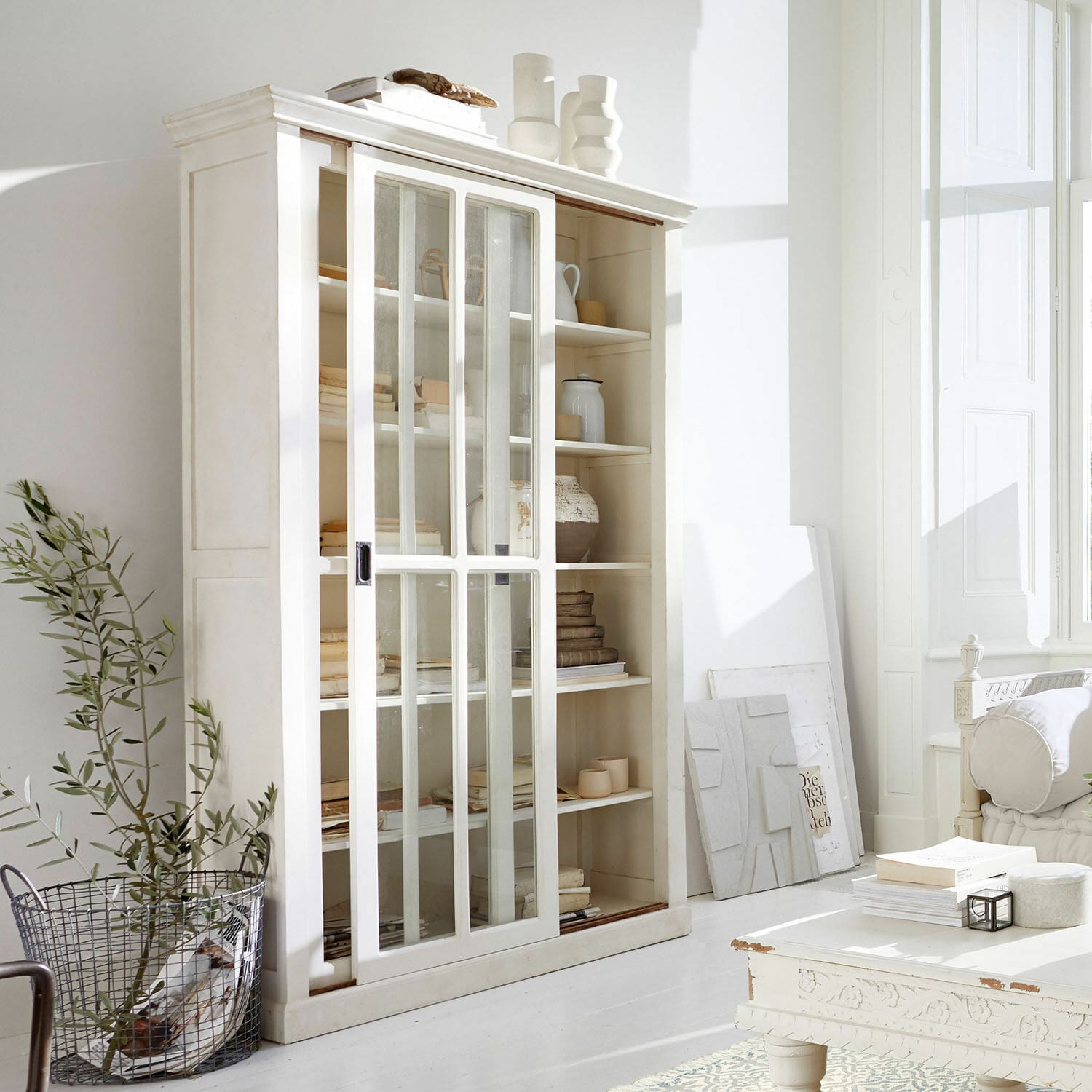Vetrina Brouns Vetrina bianca in legno con ante scorrevoli in vetro in soggiorno luminoso e moderno