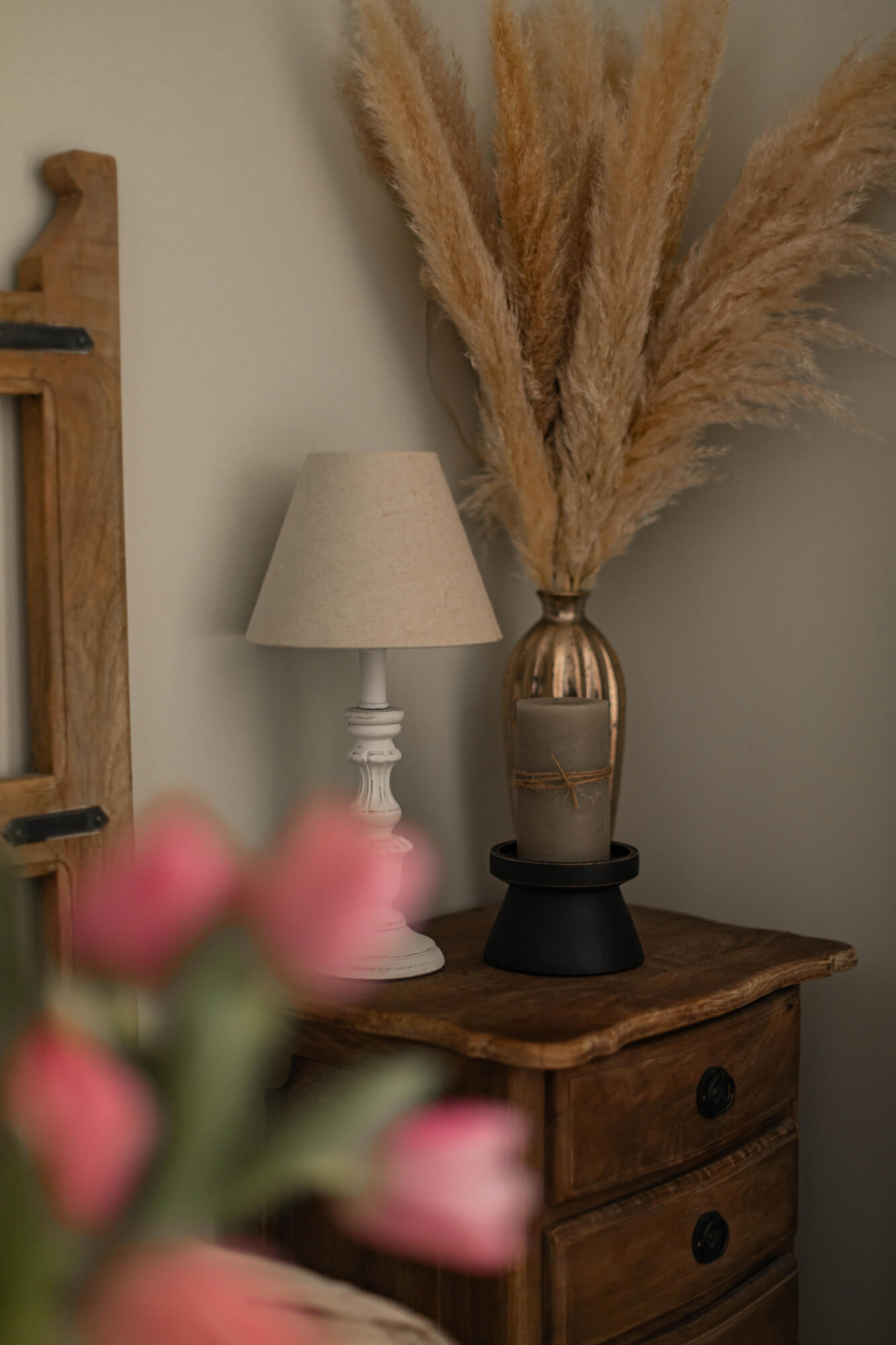 Comodino in legno con lampada e decorazione in erba della pampa in colori naturali per camera da letto
