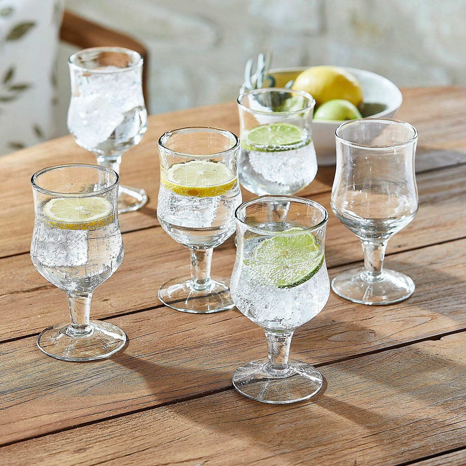 Set di 6 bicchieri Gaëtane Set di sei bicchieri in vetro trasparente con fette di limone e lime su tavolo di legno