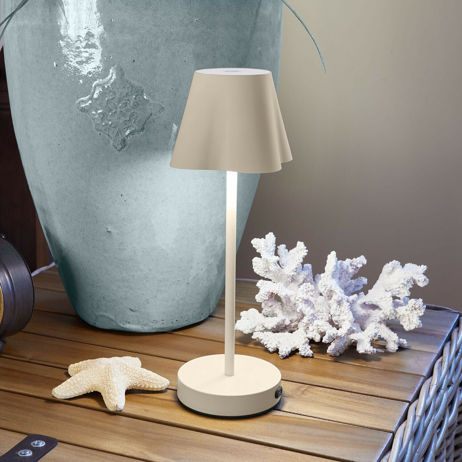 Lampada da tavolo ricaricabile Tenari Lampada da tavolo beige in metallo su tavolo in legno con decorazioni marine e vaso grande