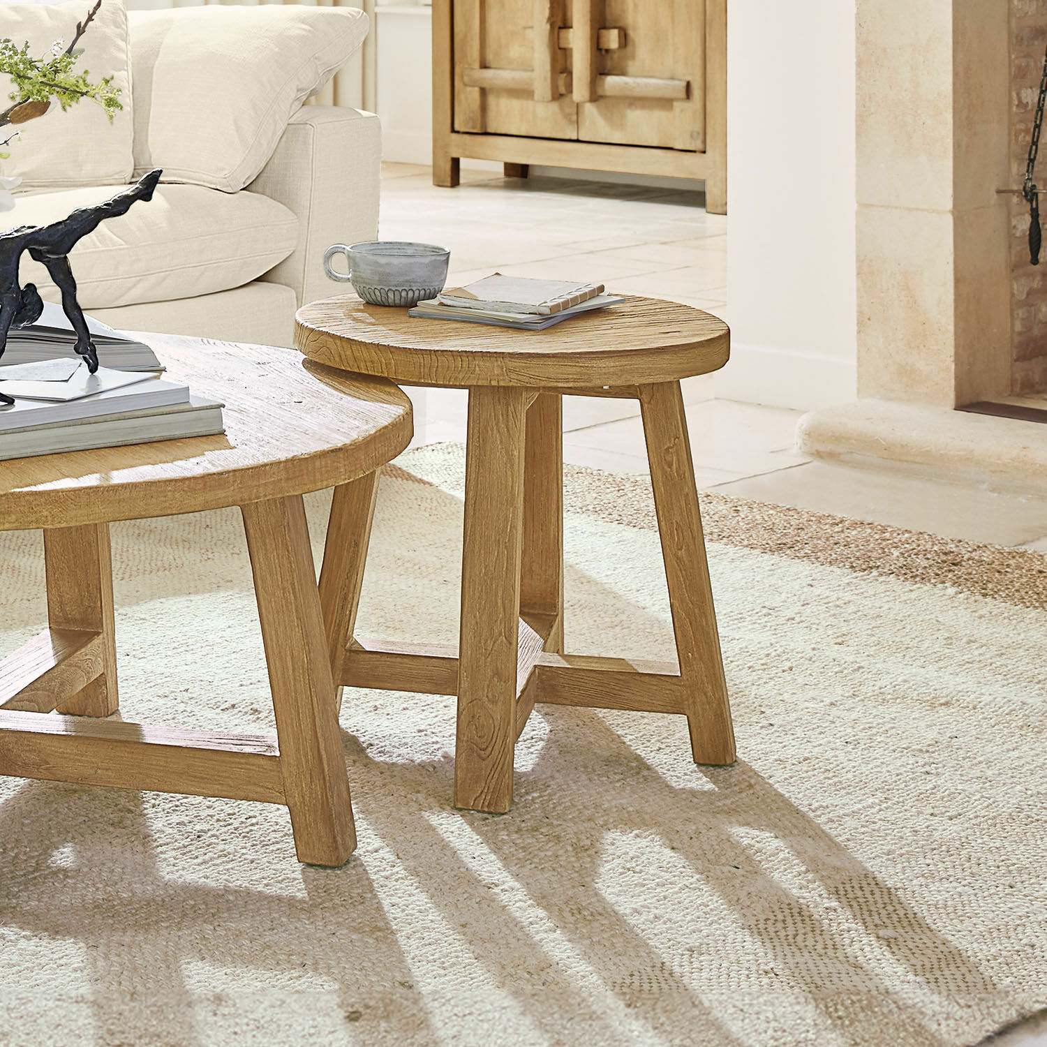 Tavolino di complemento Gorivel Tavolino rotondo in legno naturale su tappeto chiaro in soggiorno con divano beige