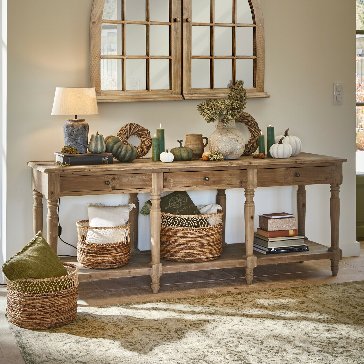 Consolle Misérieux Consolle in legno con decorazioni autunnali, lampada e cesti di vimini in un interno accogliente