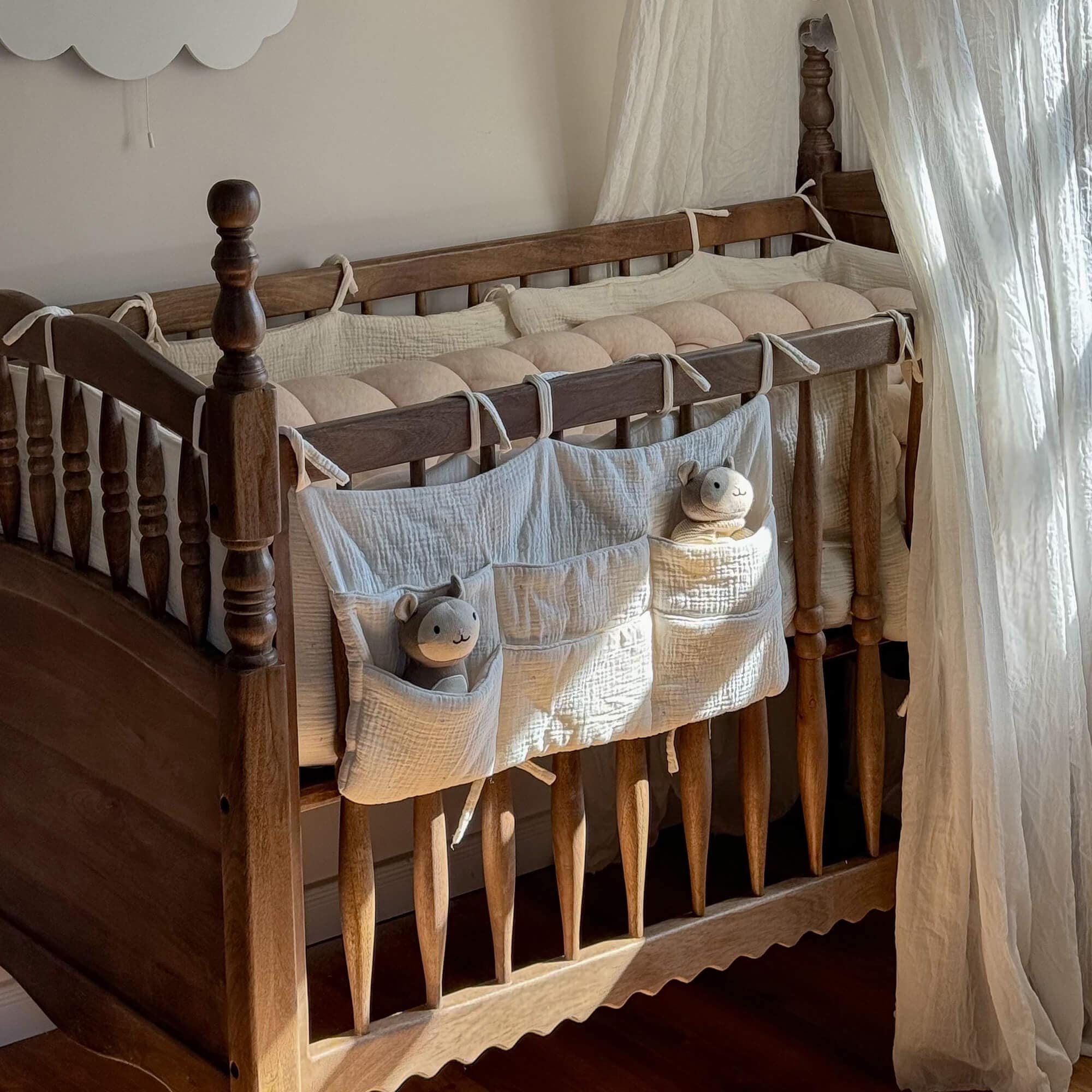 Lettino in legno con protezione in cotone crema e peluche nelle tasche per cameretta