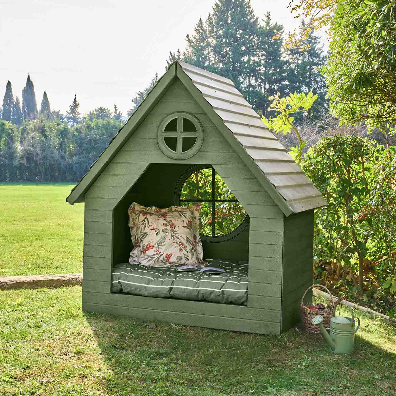 Casetta da giardino verde in legno con cuscino e finestra rotonda, perfetta per il relax all'aperto