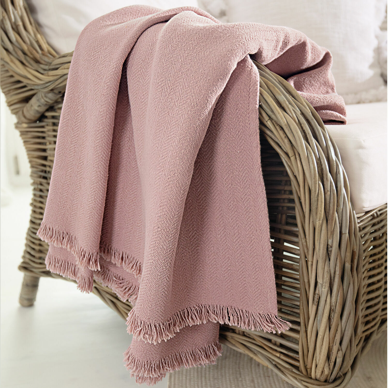 Coperta Herepian Coperta rosa in tessuto morbido con frange su poltrona in vimini per soggiorno