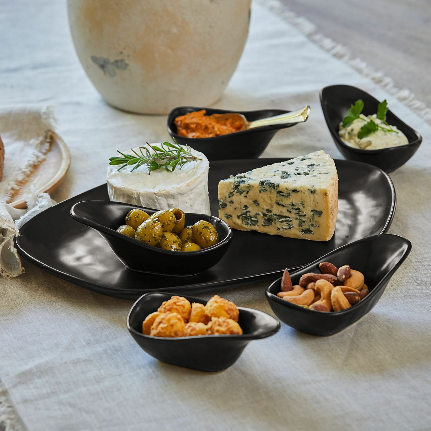 Set di 6 ciotoline su piatto Biarré Set da portata in ceramica nera con formaggi, olive e noci su tovaglia di lino