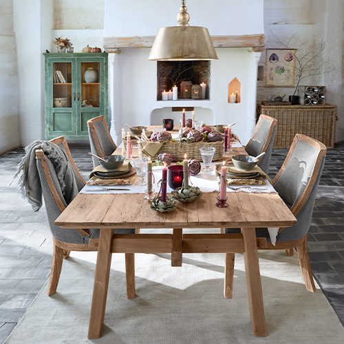 Tavolo da pranzo rustico in legno con sedie imbottite grigie e decorazioni festive eleganti